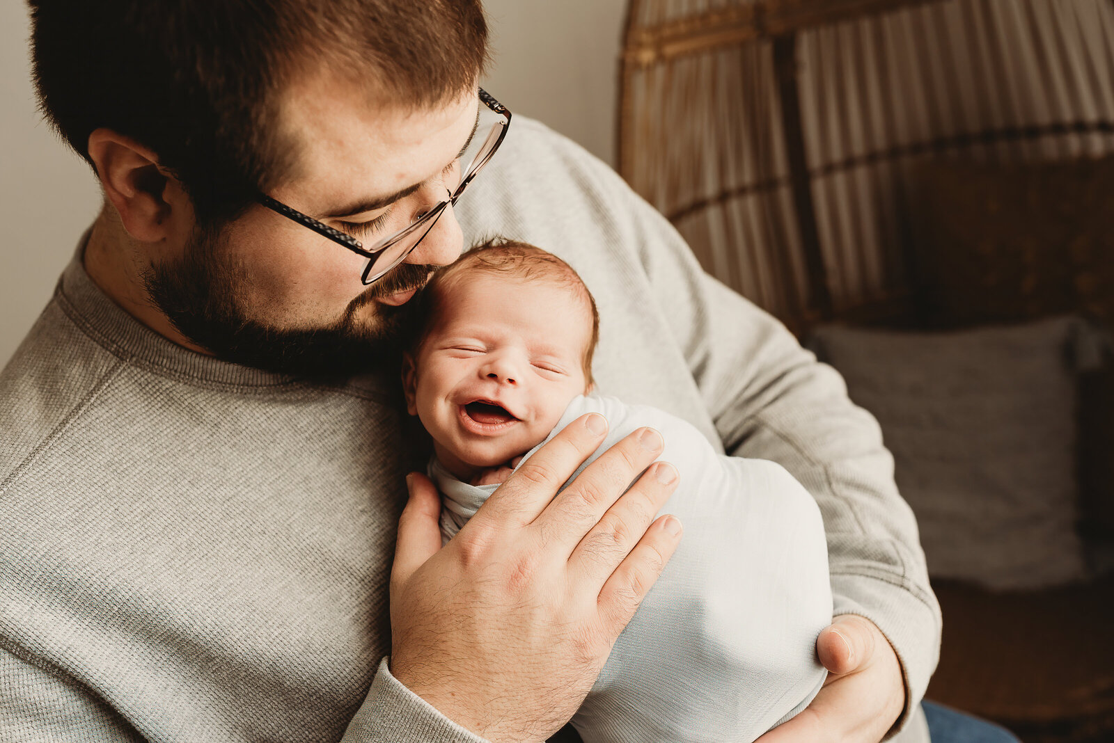 A newborn shares a smile while he's snuggling with his dad during a photoshoot at Nikii Pix Studios in Bismarck, ND