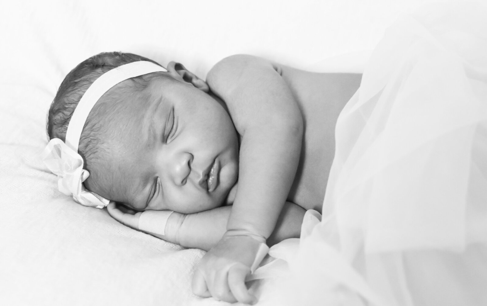 black and white photo of a sleeping newborn baby photographed by Millz Photography in Greenville, SC