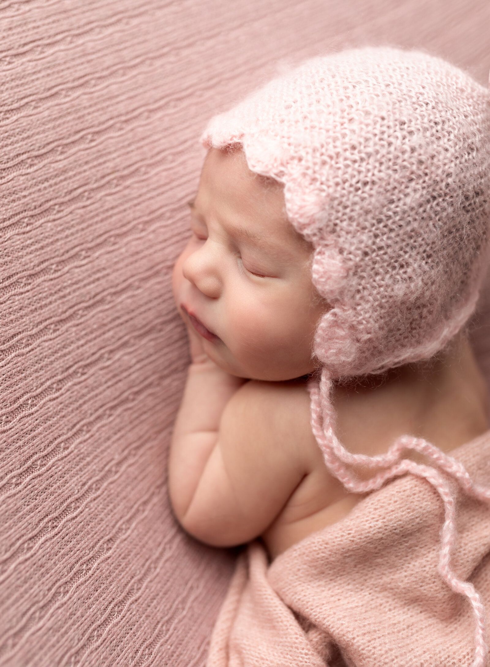newborn baby girl in pink for photoshoot