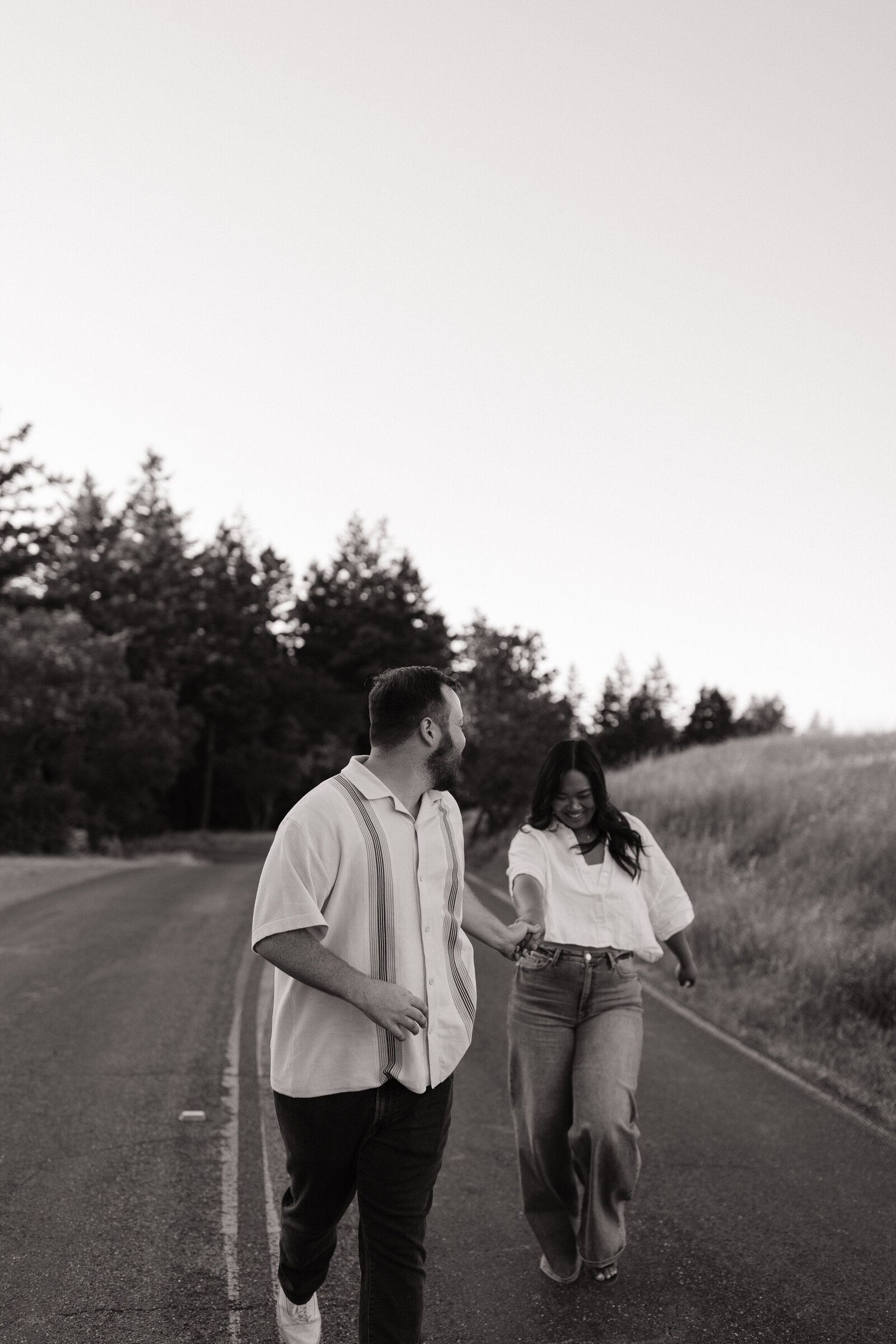 Motion-filled shot of couple running downhill during golden hour