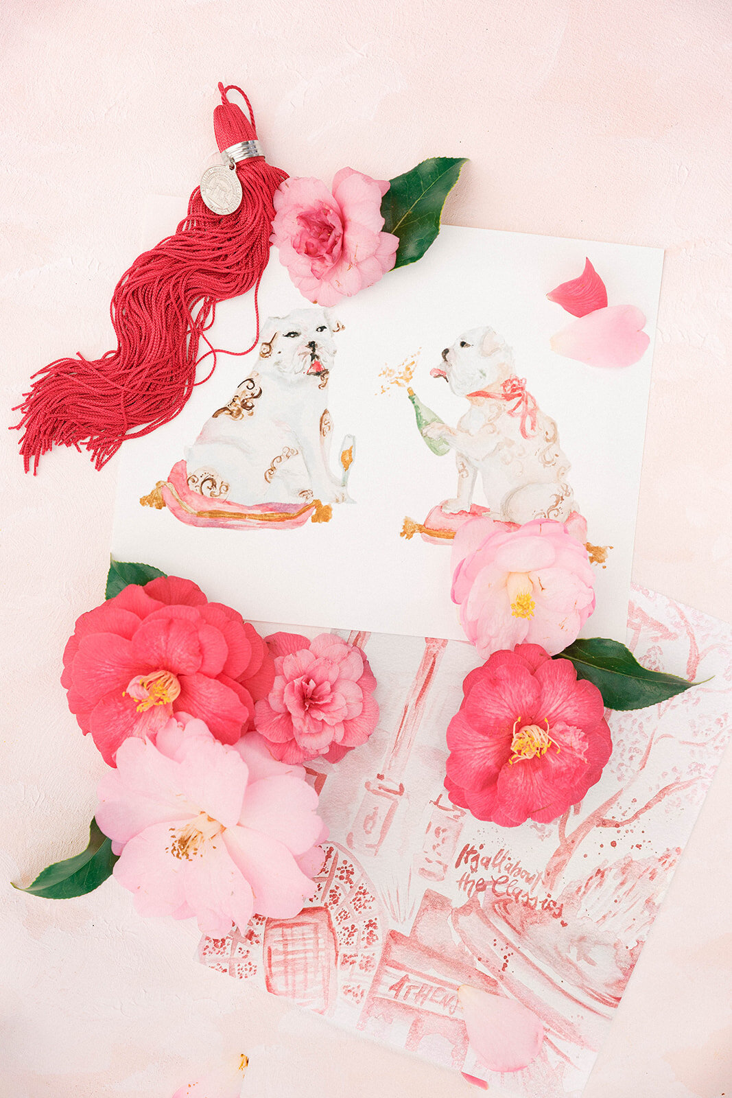 Flay lay of a University of Georgia graduate's artwork and tassel with pink flowers