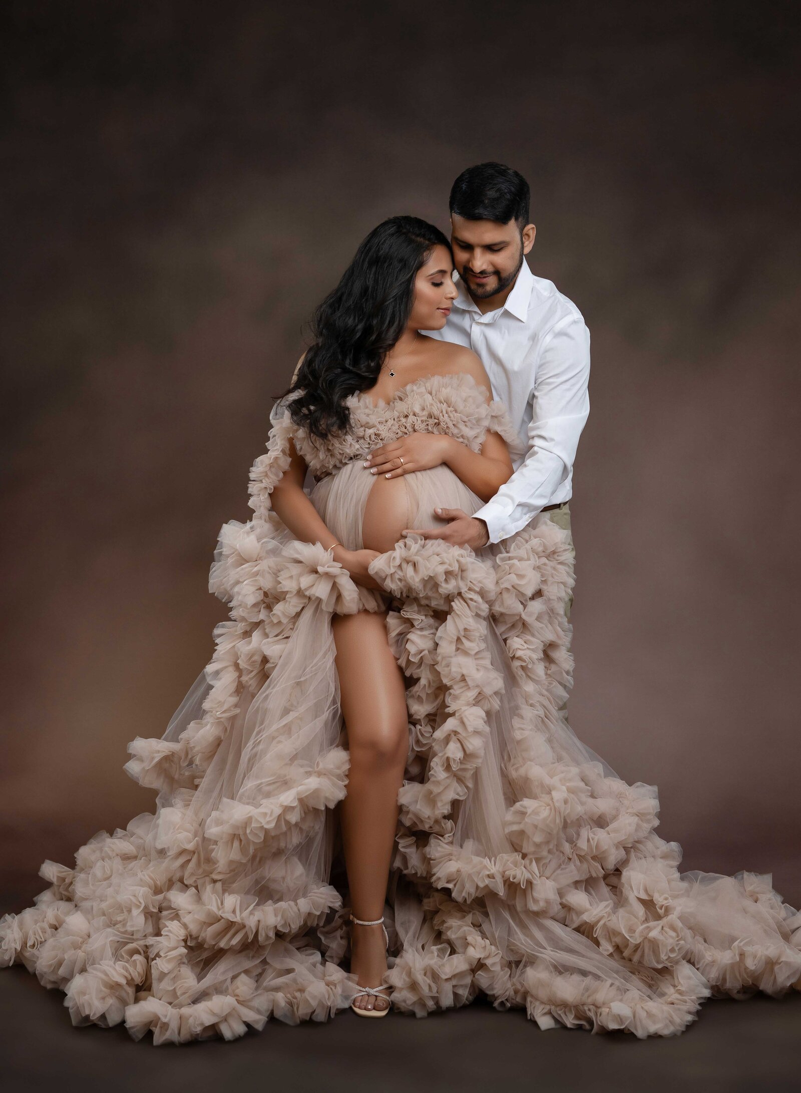 Man and women cuddling in and holding baby bump. Pregnancy photo taken in Atlanta, GA.