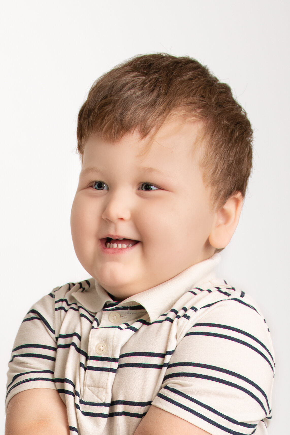 young boy smiles for indoor studio school modern pictures