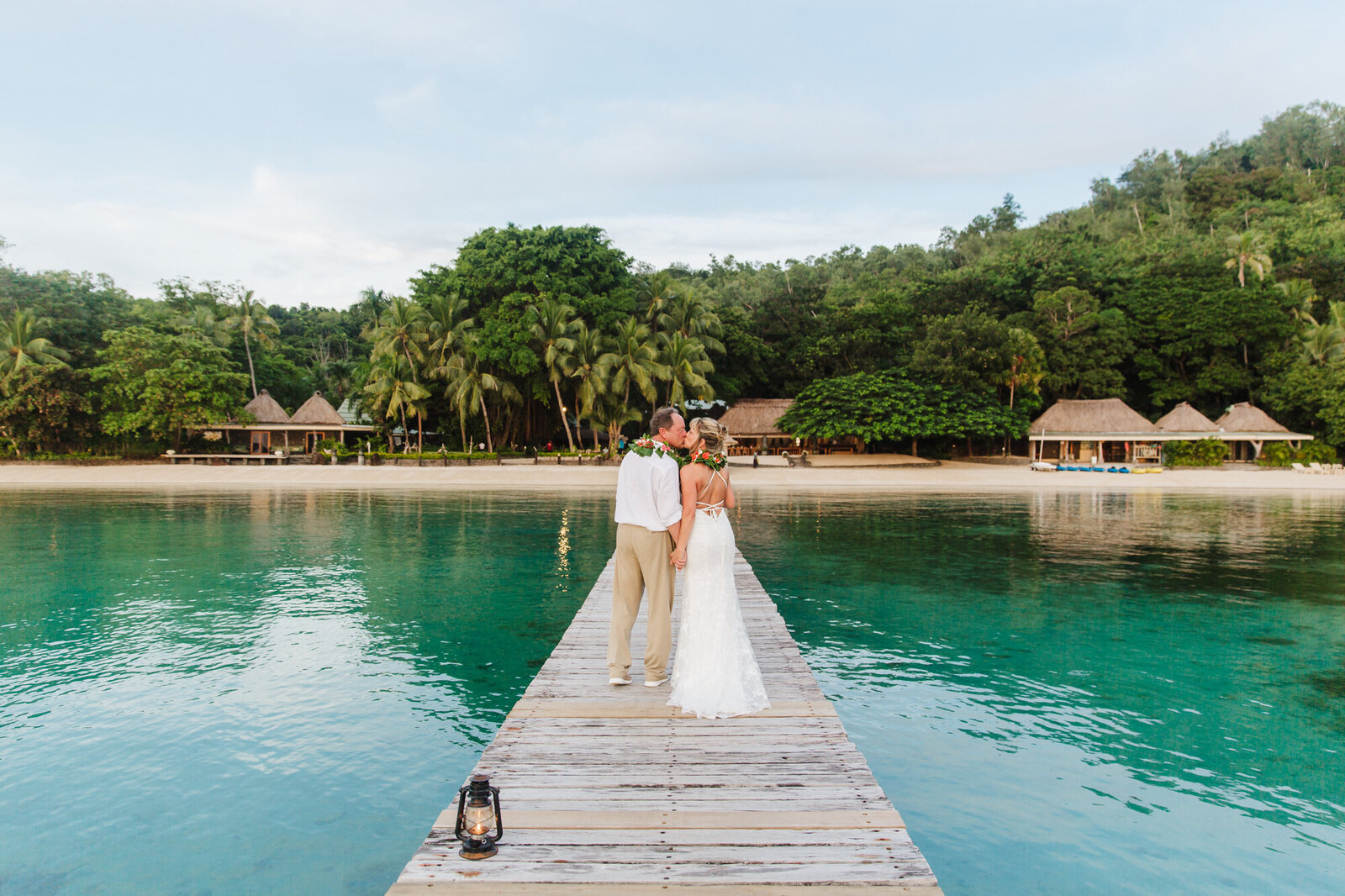 couple walking down a dock looking back over their shoulder