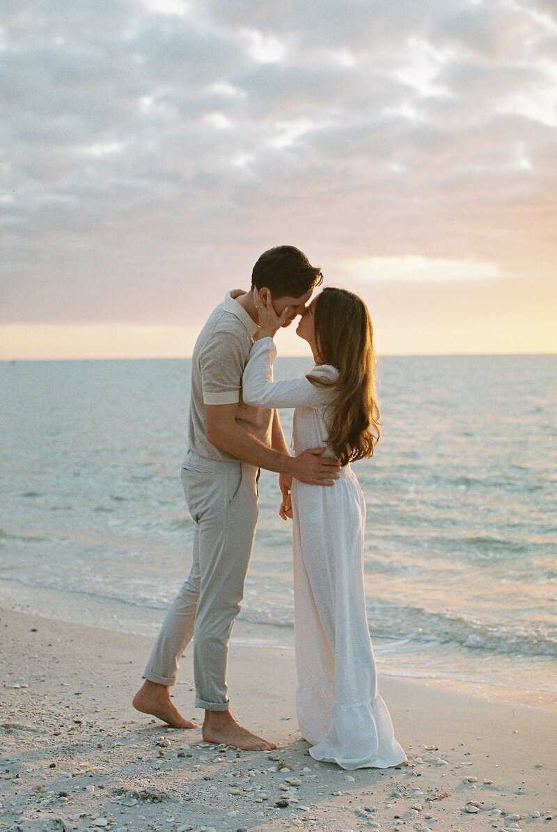 couple kissing at beach photographed by naples photographer