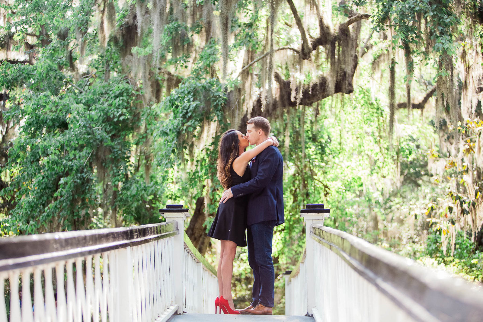 Engaged couple stand on a white bridge, Magnolia Plantation, Charleston, South Carolina