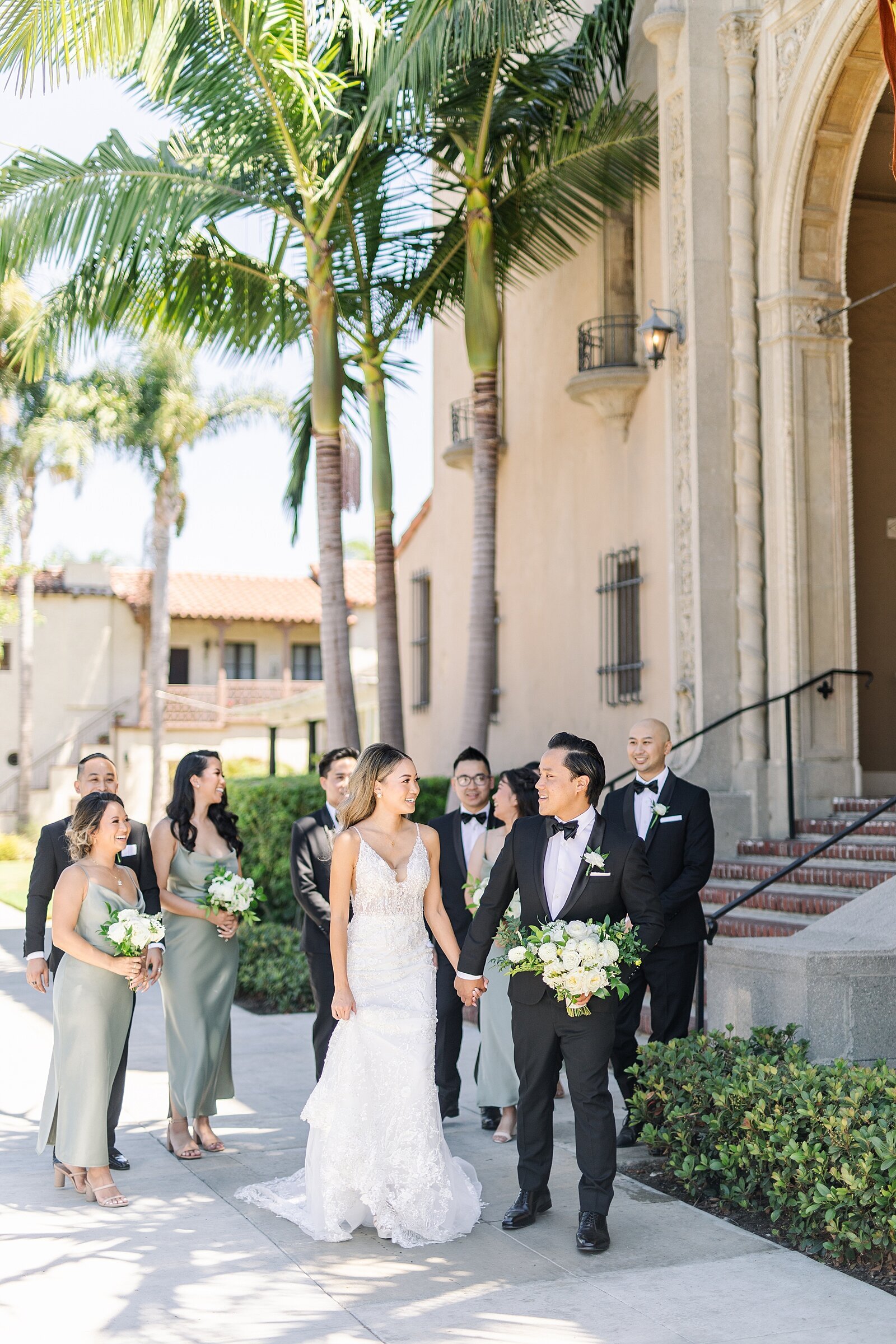 Bride and groom walking outside the Ebell of Long Beach with bridesmaids and groomsmen.