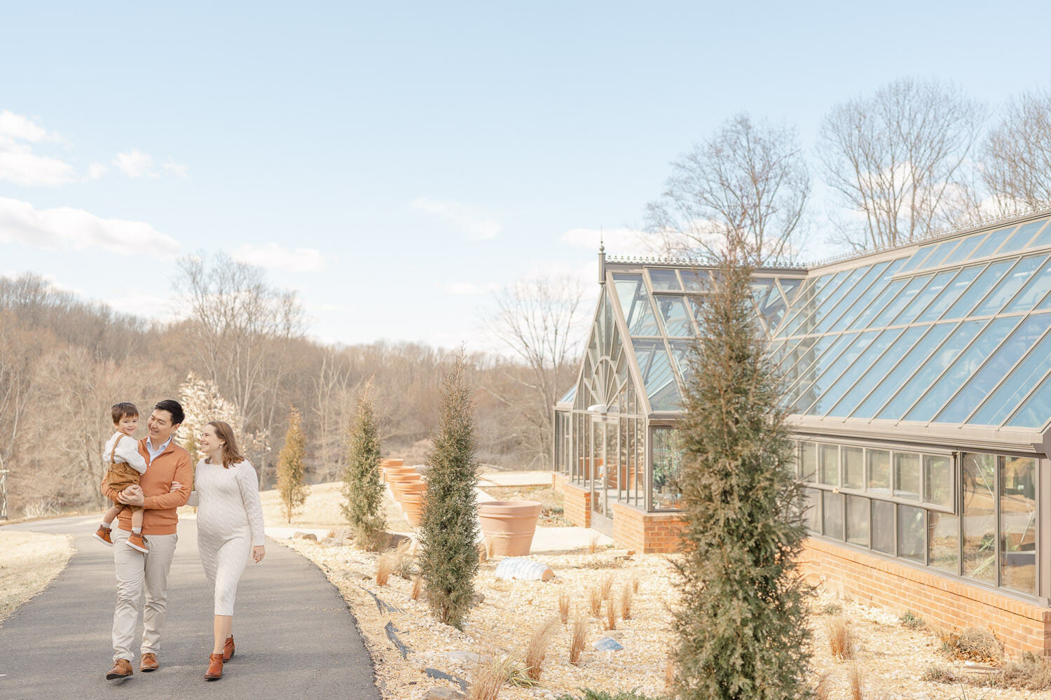 family walk outside the greenhouse during Reston, VA maternity picture
