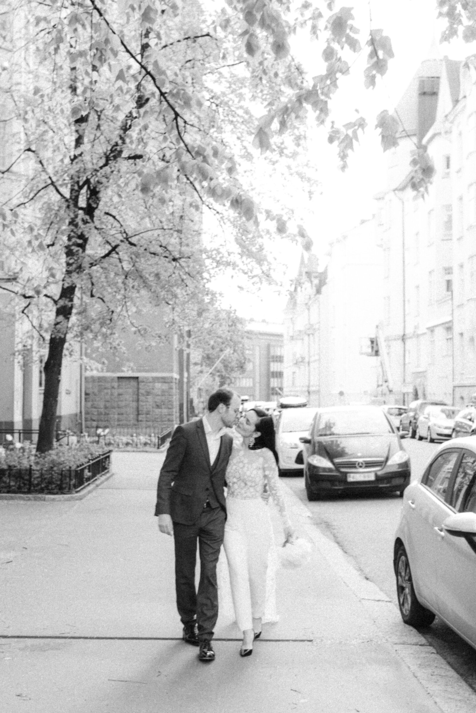 Elegant and madly in love  wedding couple walking on the street in Helsinki. European elopement photographer Hannika Gabrielsson photographed this image in spring.