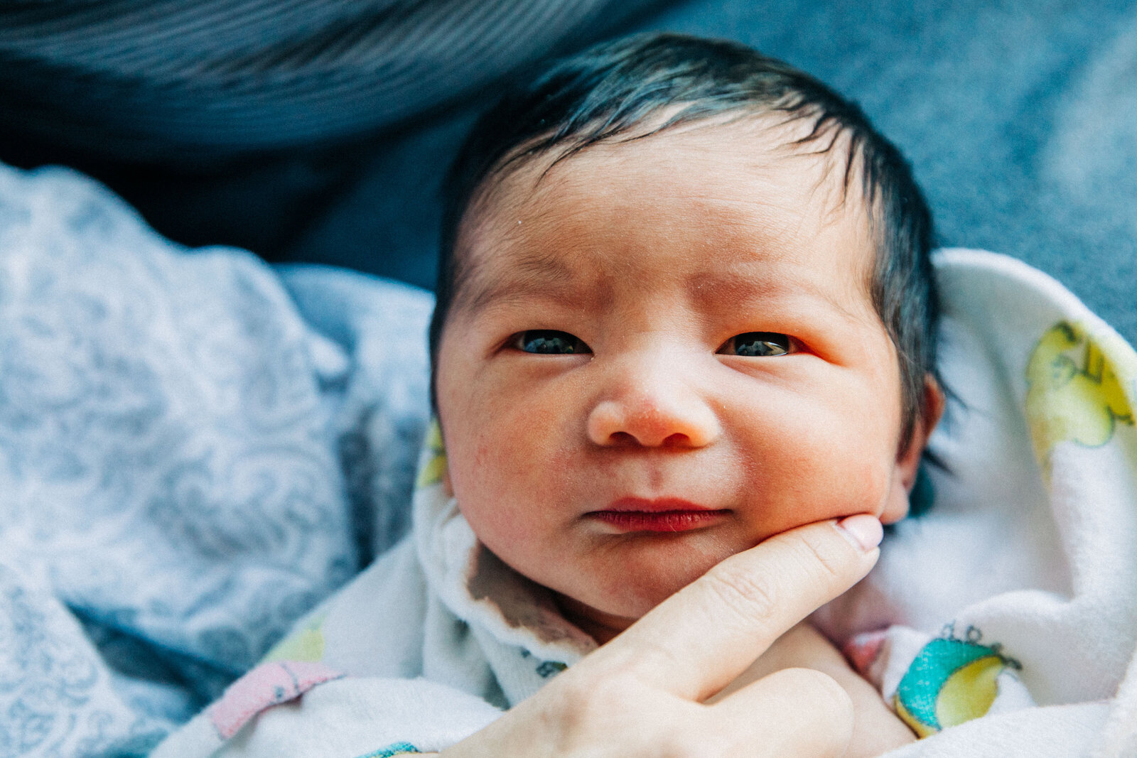 closeup of newborn baby boy's face looking at the camera