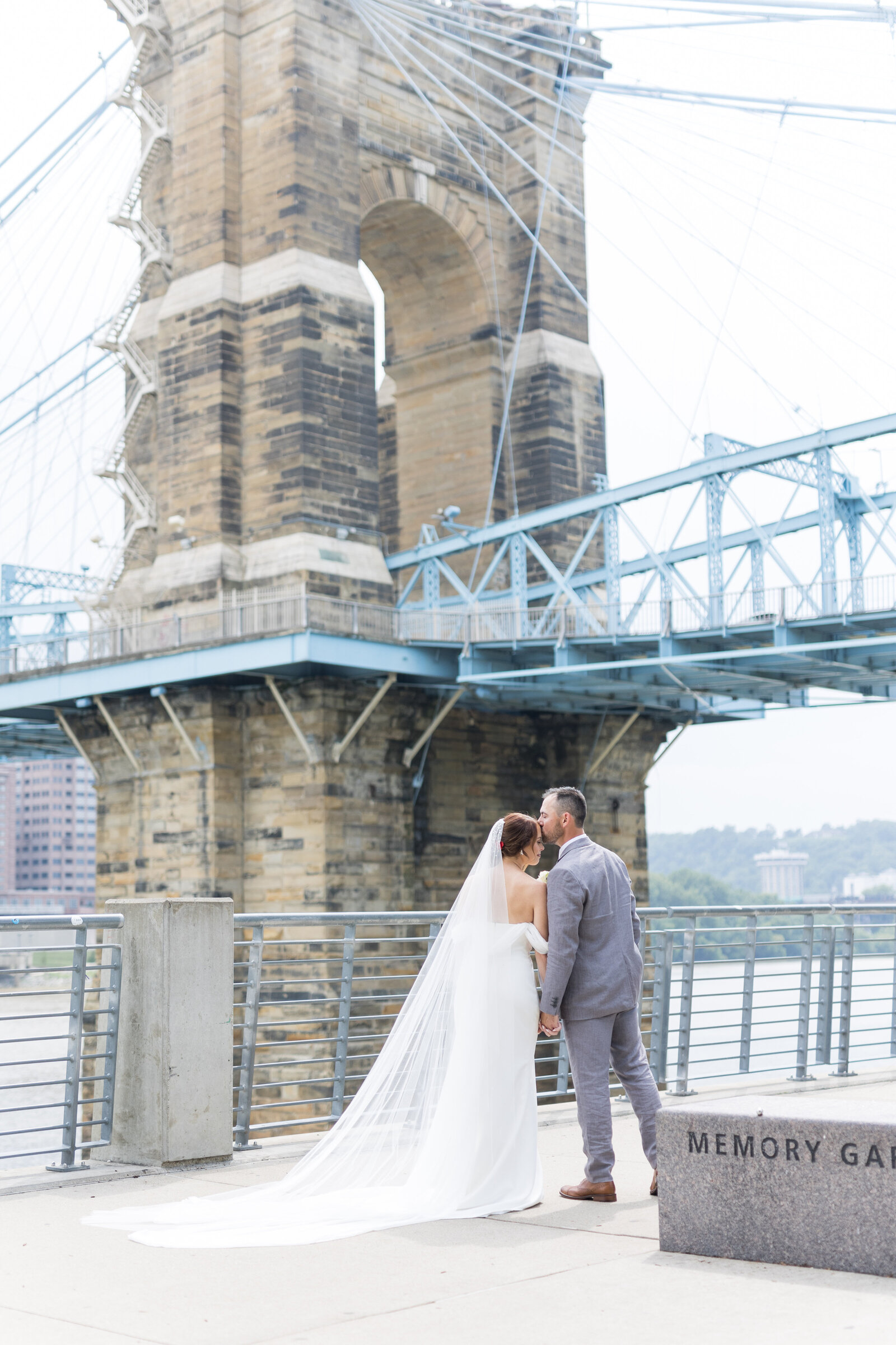 bride and groom in front of bridge