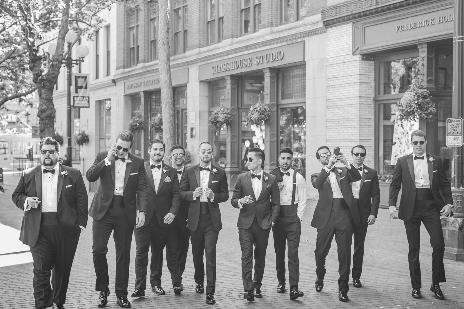 Black and white photo of groomsmen walking on sidewalk