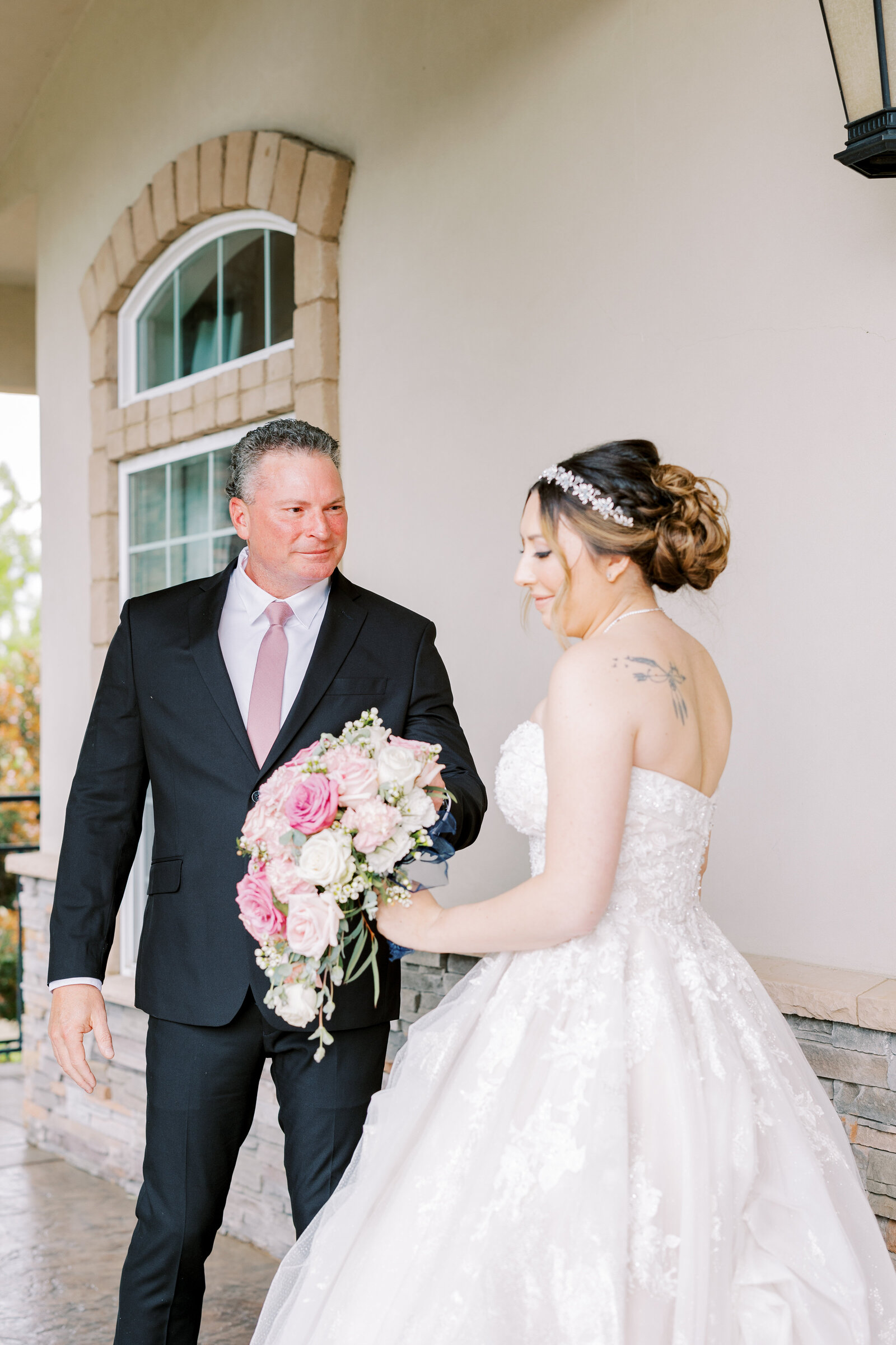 bride and her father for a first look before the wedding reception at Wolfe Heights  while she holds her rose bouquet captured by sacramento wedding photographer