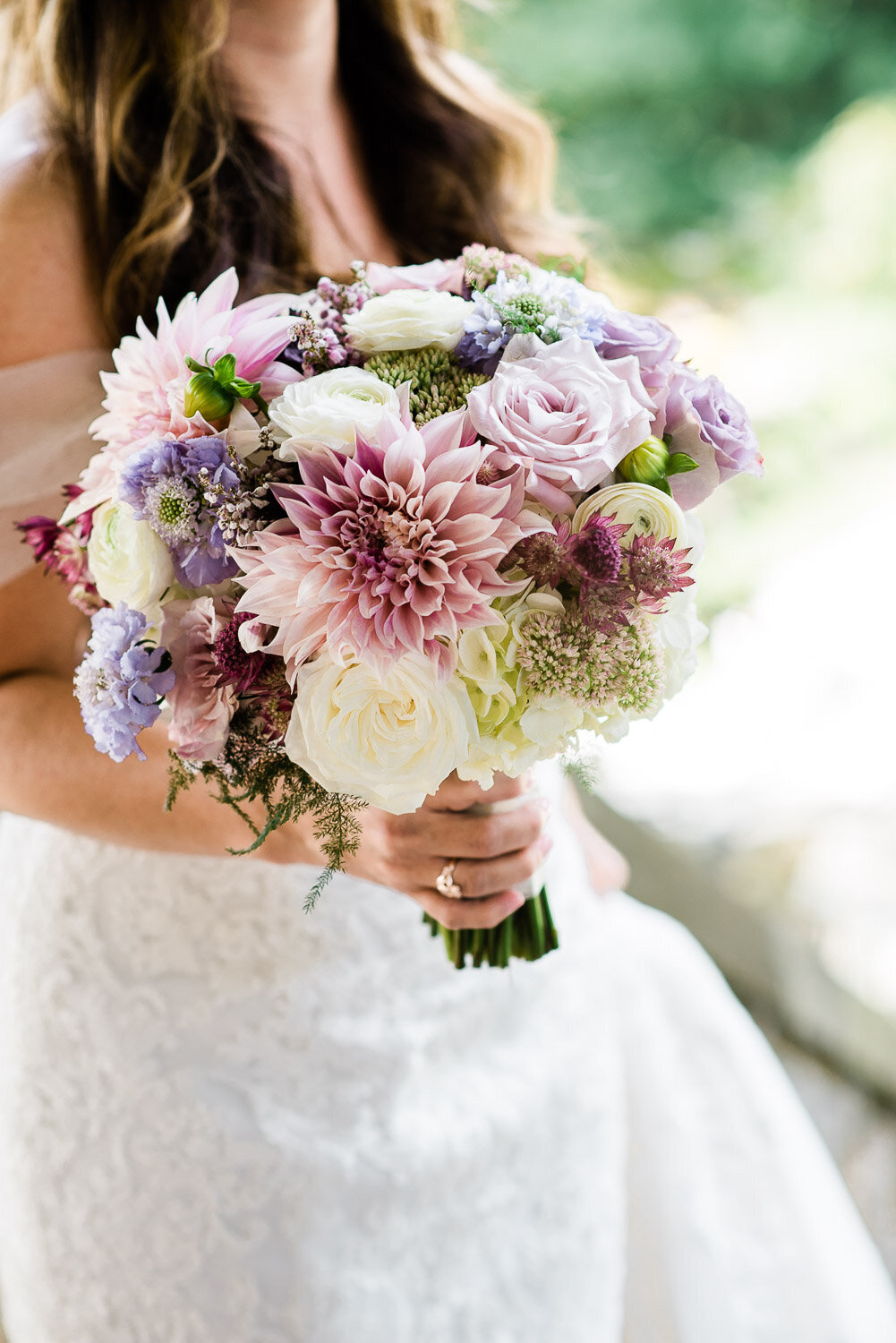 bride holding pink and lavender bouquet