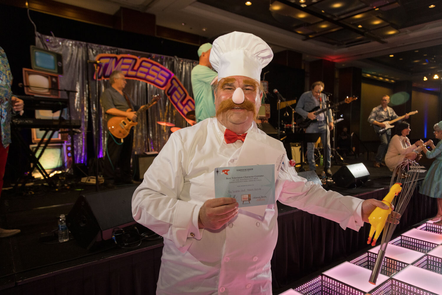 A man in a chef costume is holding a piece of paper