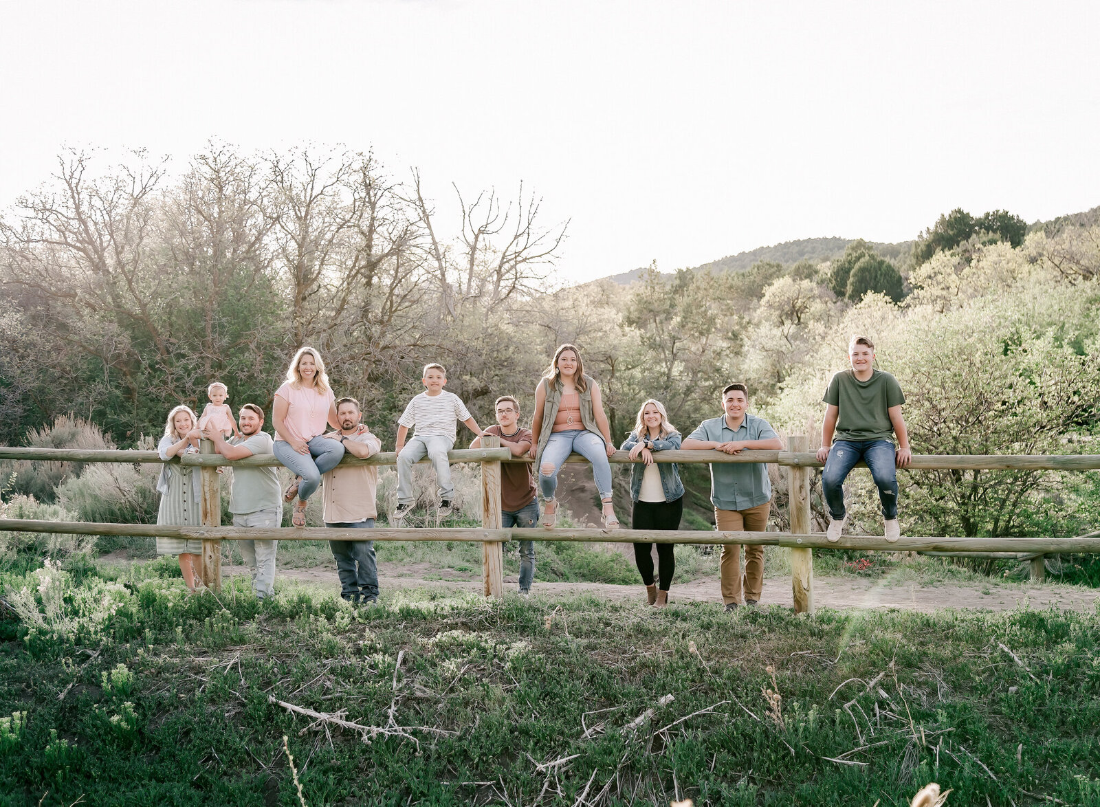 A large family poses on a fence in Herriman Utah.