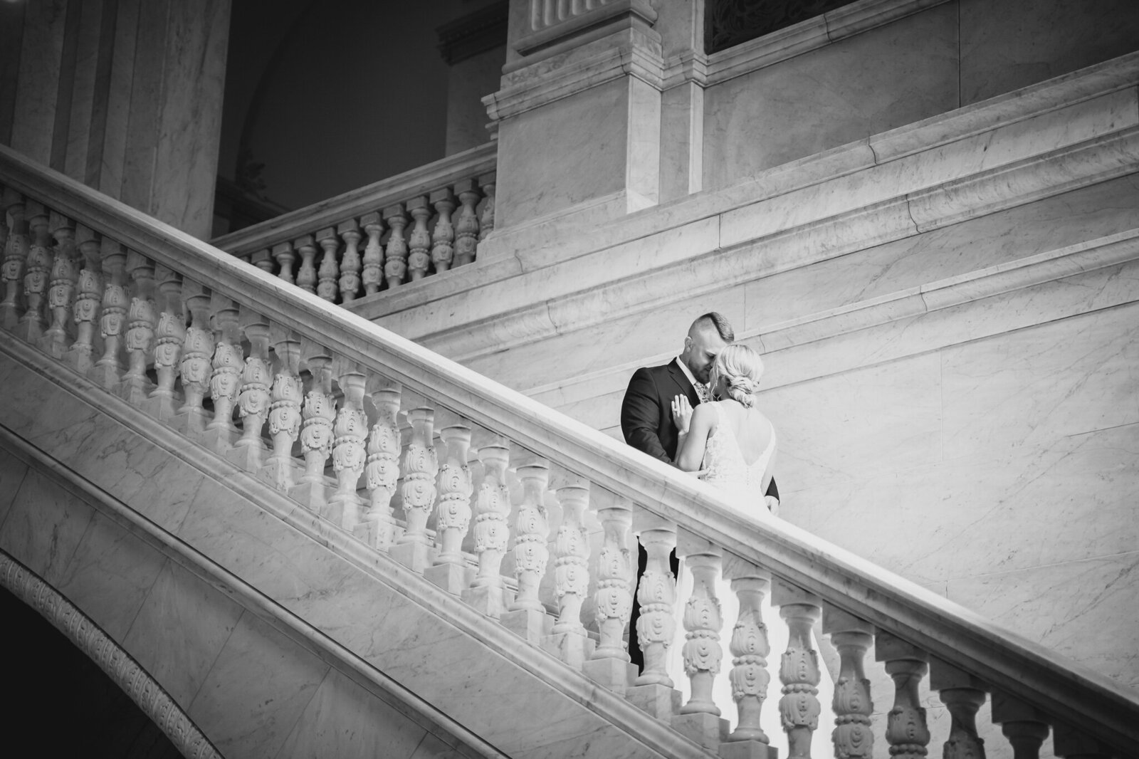 Bride and groom, Rachel and Jeff, touch heads lovingly on a staircase in the Ohio State House in Columbus.