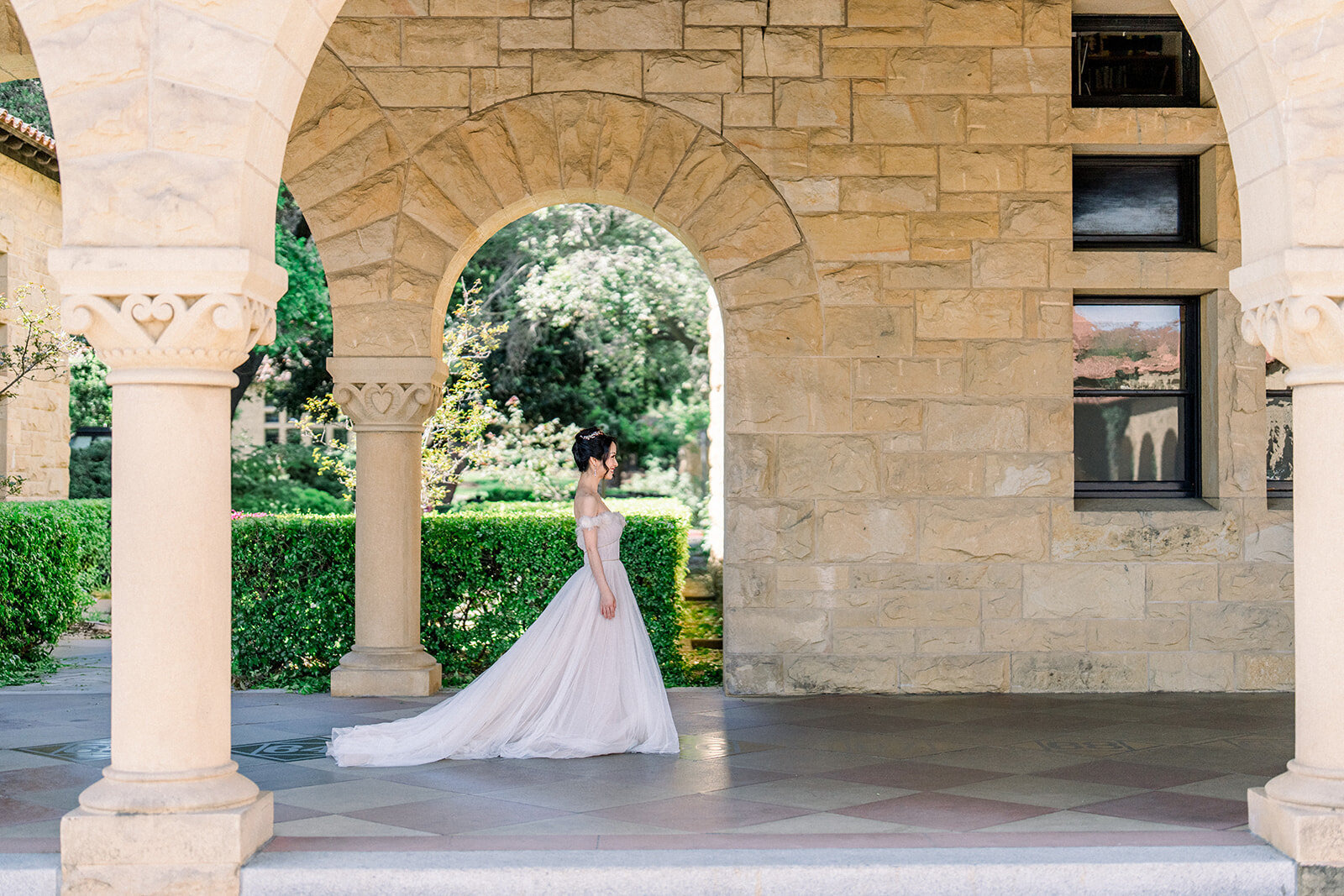 The bride poses elegantly under a charming archway at the luxurious Filoli Estate wedding in Woodside, California.