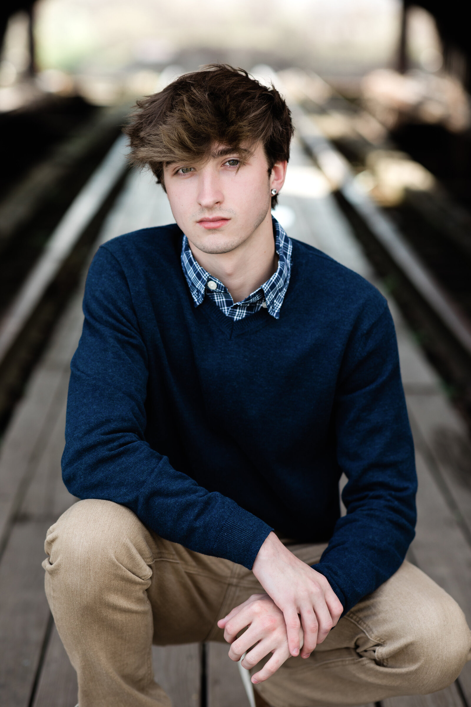senior boy in blue sweater sitting for senior portraits cleveland senior photographer