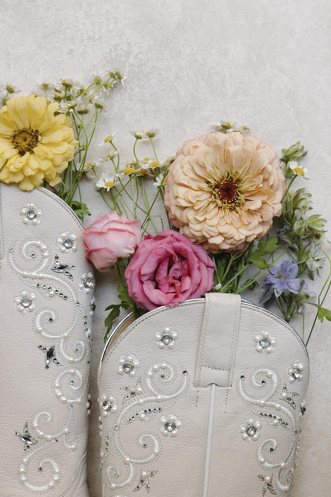 White cowboy boots filled with wildflowers