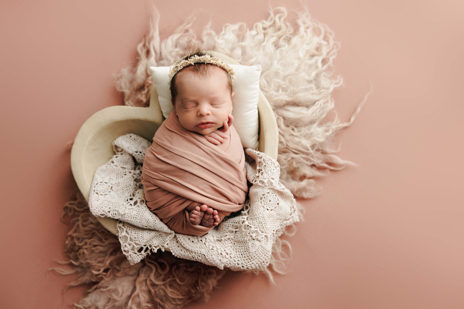 Newborn baby girl in heart shaped bowl