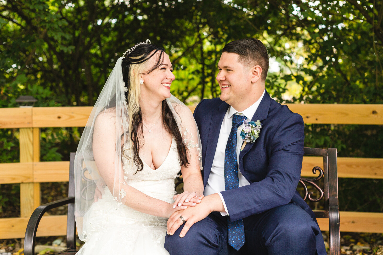 bride and groom laughing while sitting on a bench micro ohio wedding
