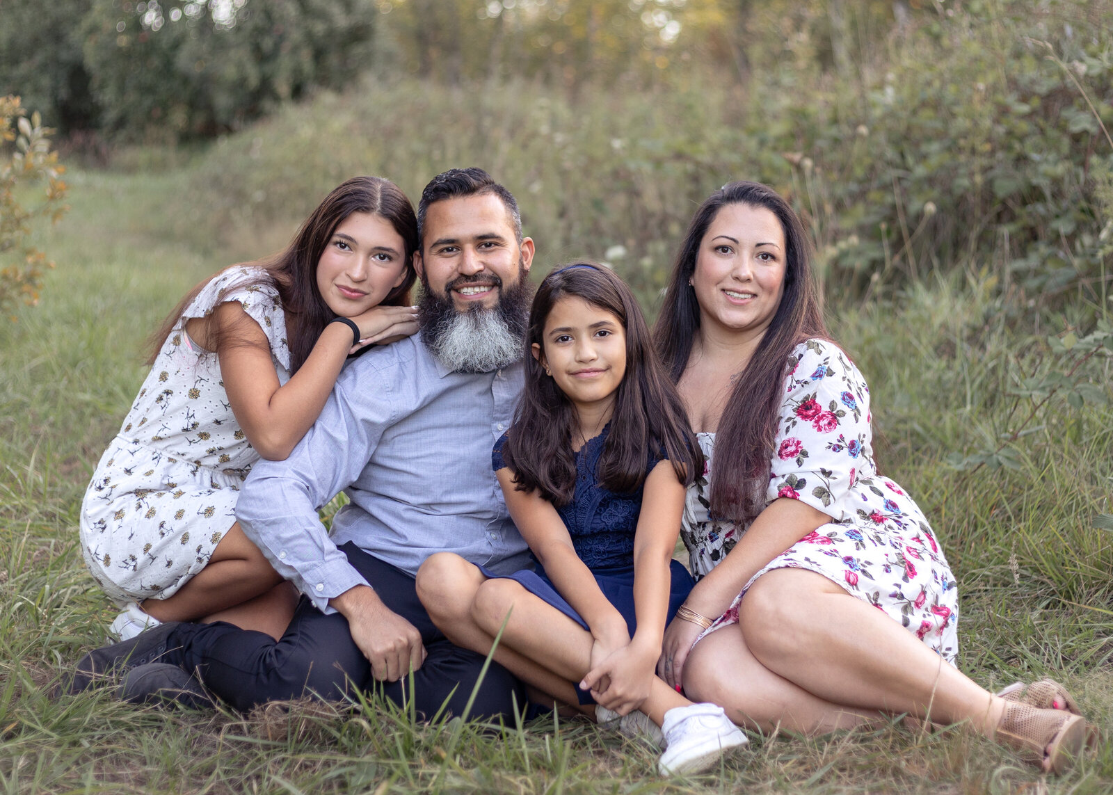 Family of 4 sitting in the grass