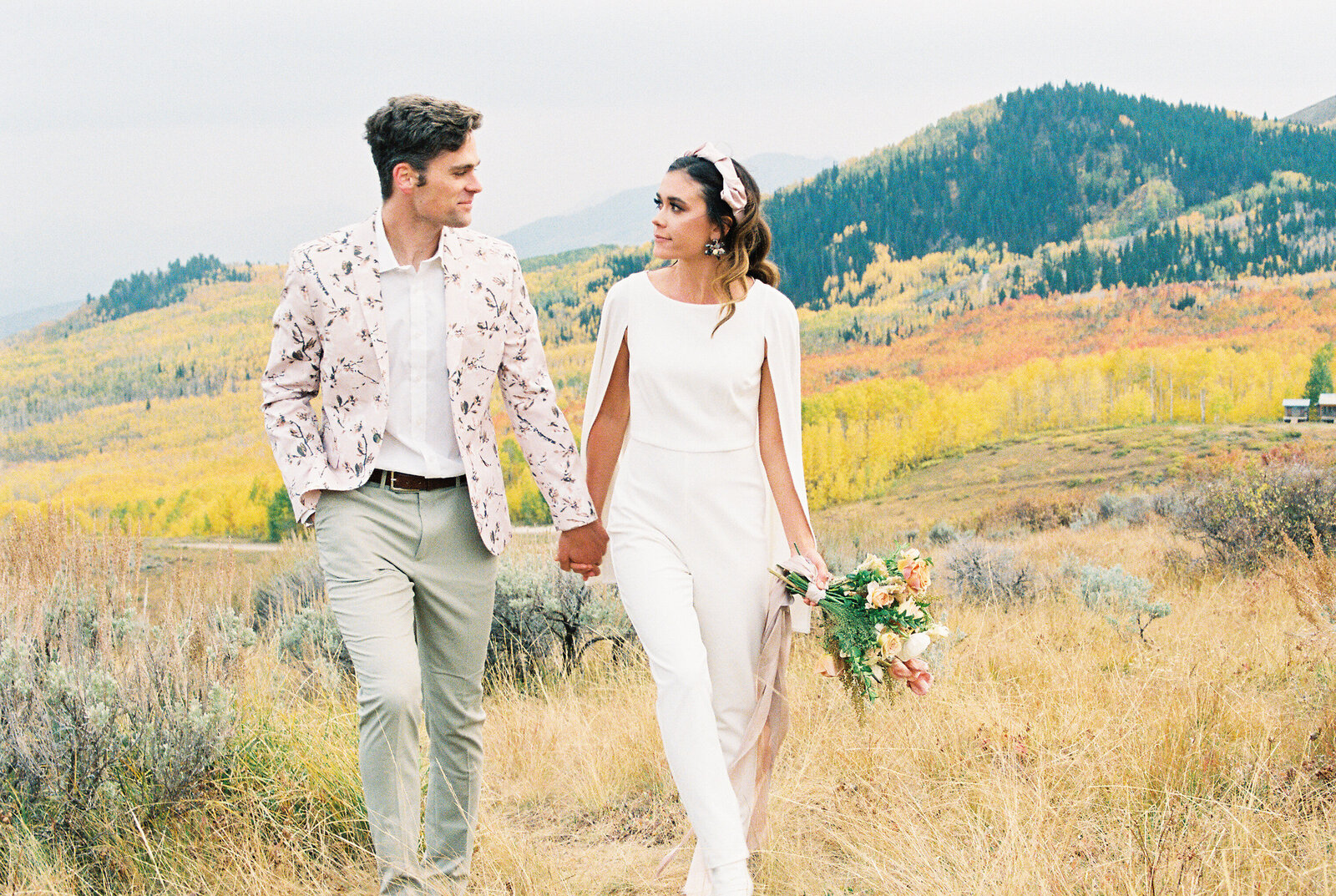 couple walking in field photographed by a Lake Tahoe wedding photographer