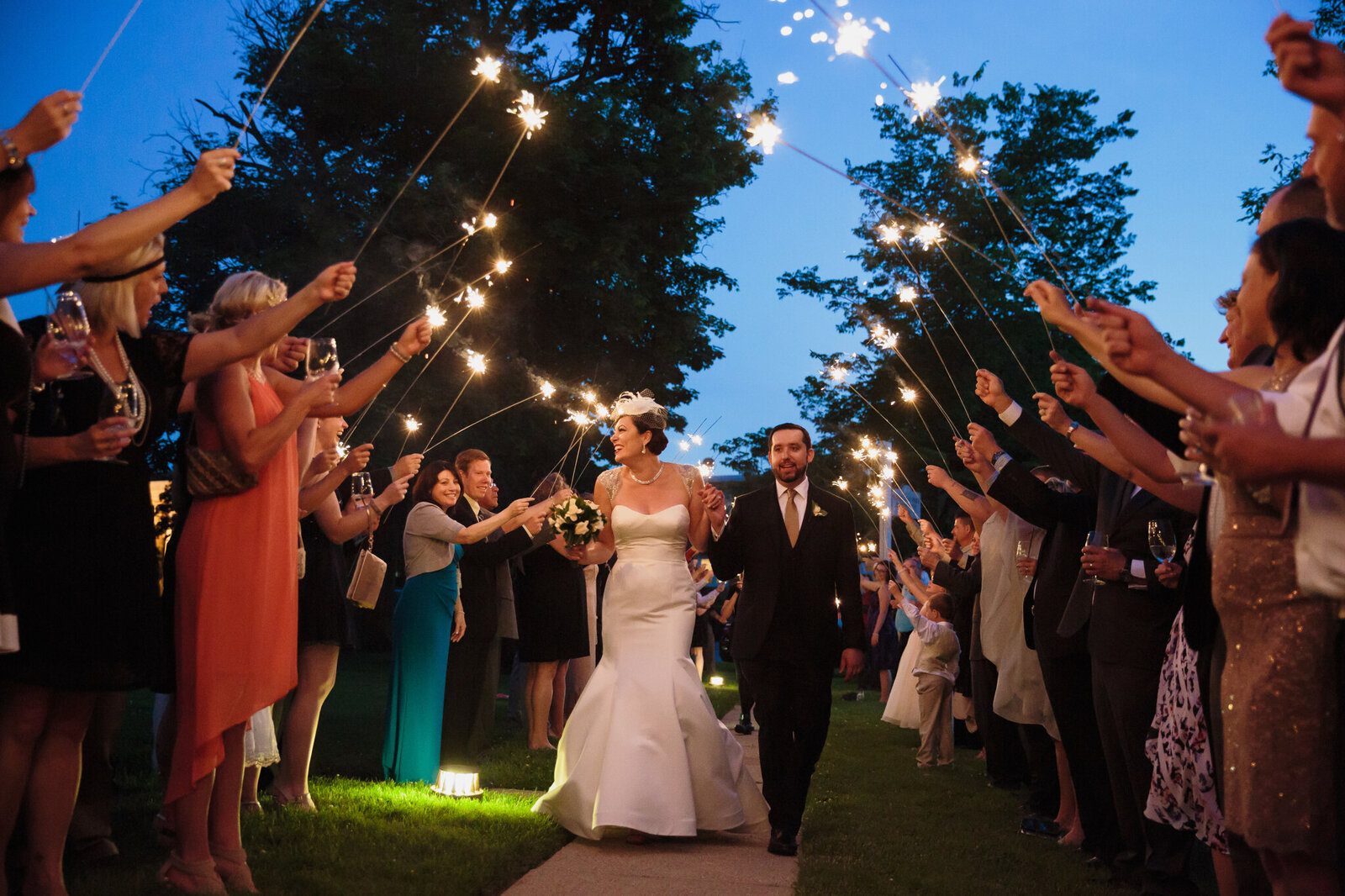 Bride and groom make their exit under arch of sparklers