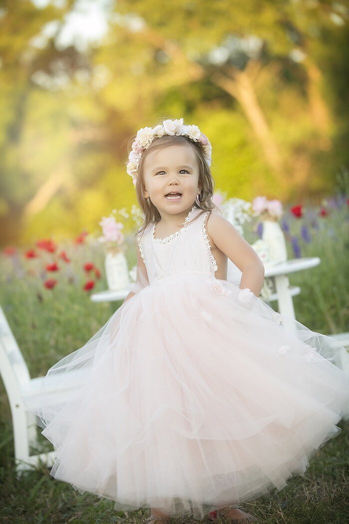 Toddler twirling in dress in the  Richardson wildflowers with a Dallas child photographer.