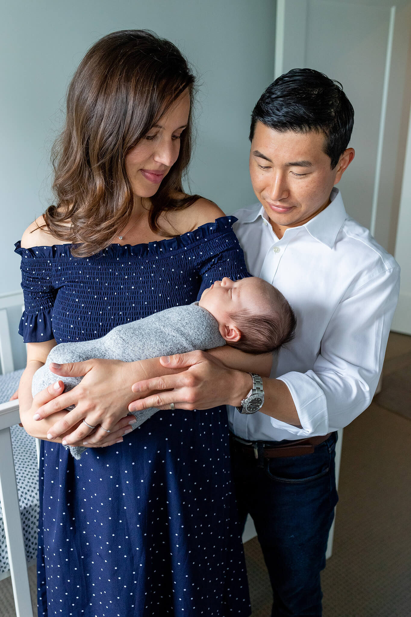 A husband and wife holding their newborn baby boy during their Northern Virginia newborn photo session.