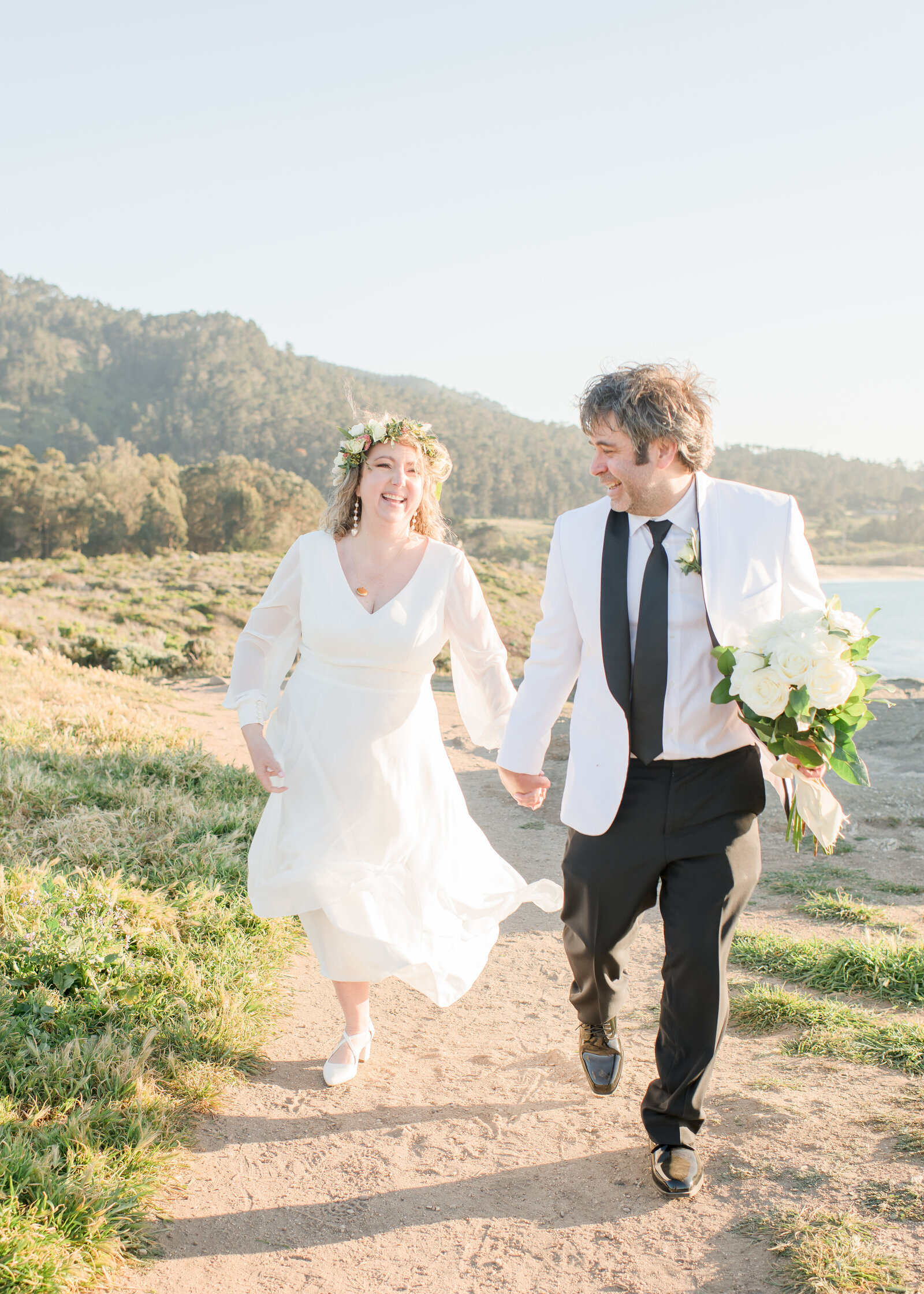 couple walking on beachwalk holding hands in carmel 