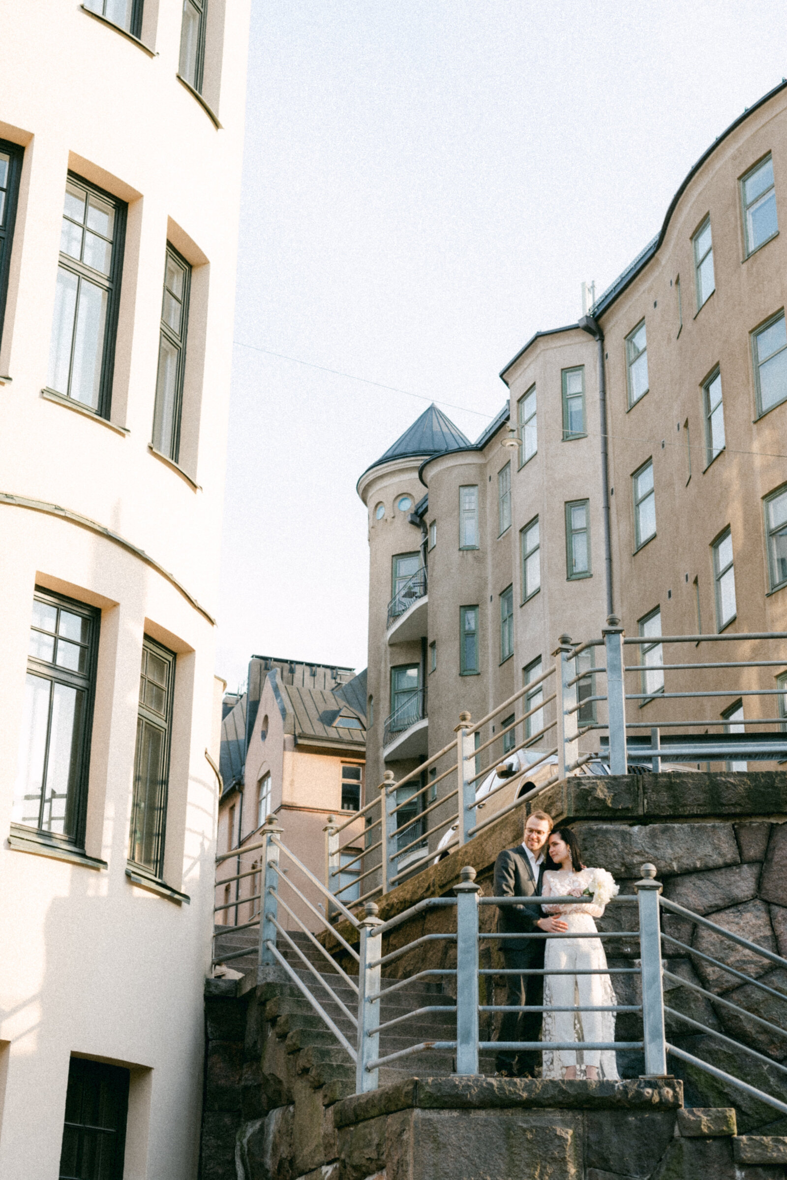 Wedding couple standing on the stairs in Katajanokka Helsinki Finland. An urban photograph captured by a nordic elopement photographer Hannika Gabrielsson.