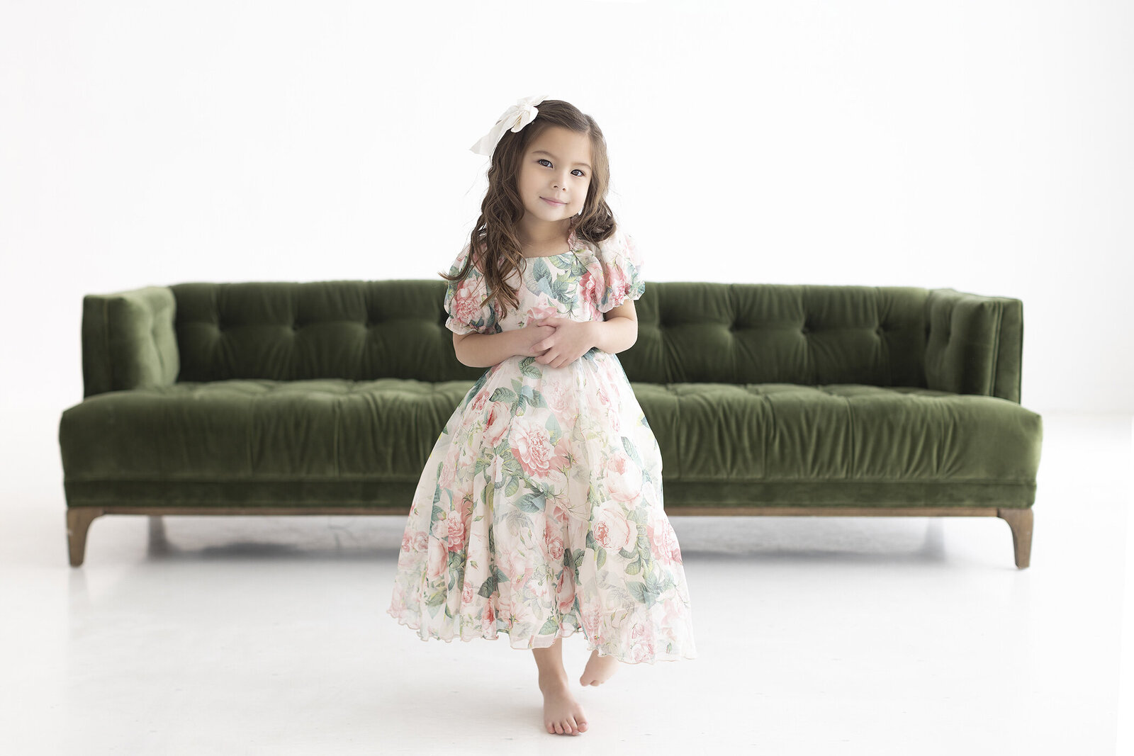Photo of young girl in whtie room wiht green couch