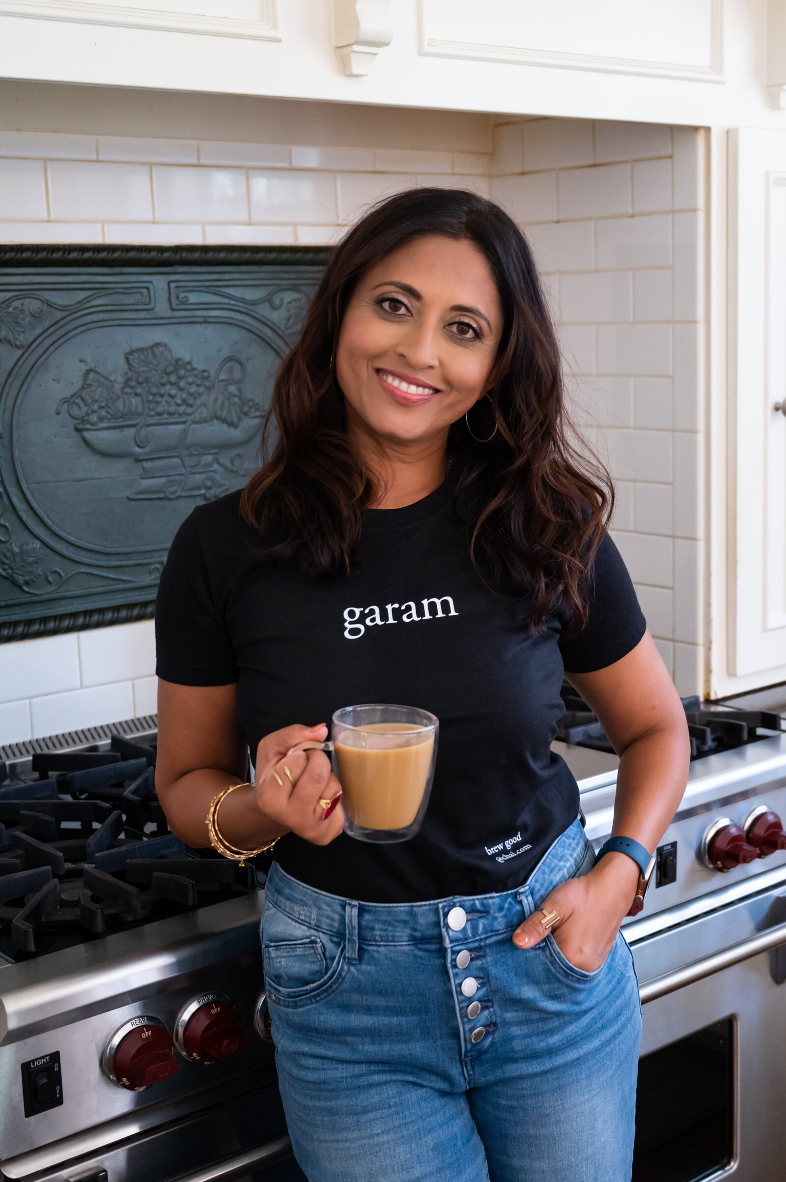 Woman in kitchen holding a cup of chai tea