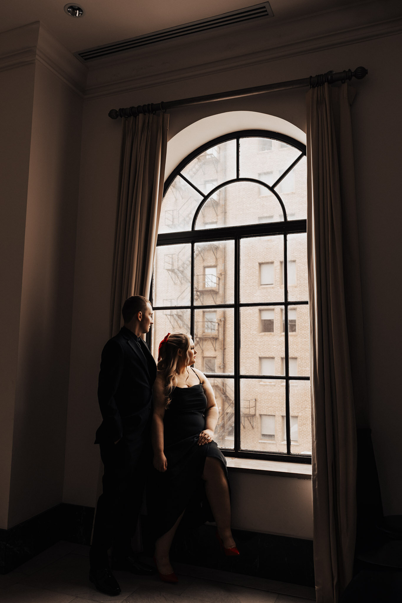 Tulsa Wedding Photographer. A couple gazing out a large window thinking about their wonderful future. 
