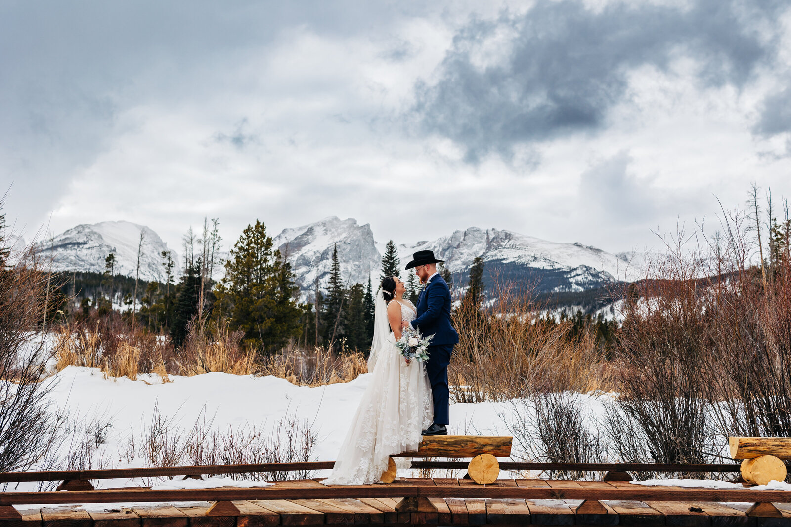 Wedding Photographer in Boulder Colorado captures cowboy wedding in winter with bride and groom with snow all around them