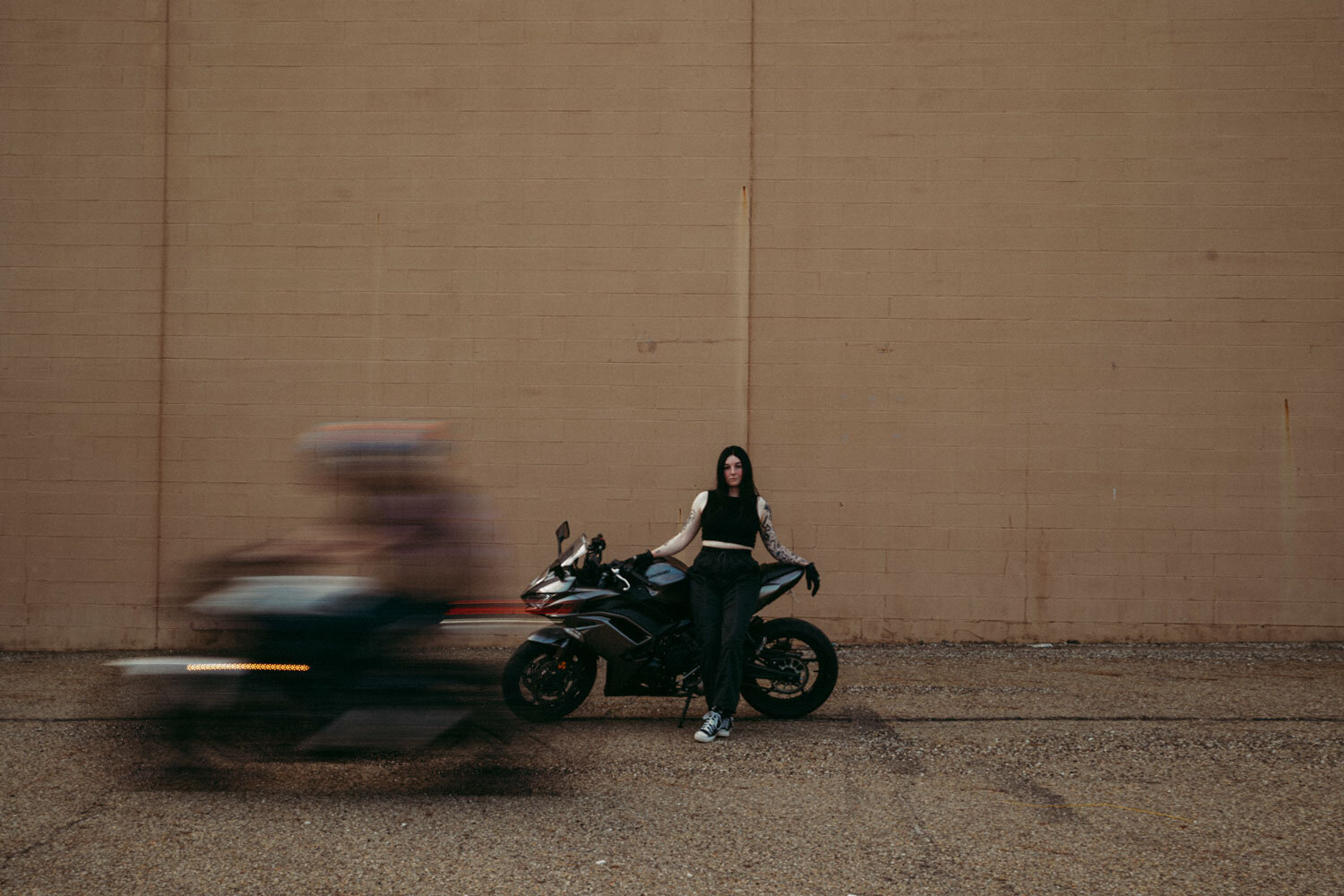 Motorcycle drives by in slow shutter speed across partner