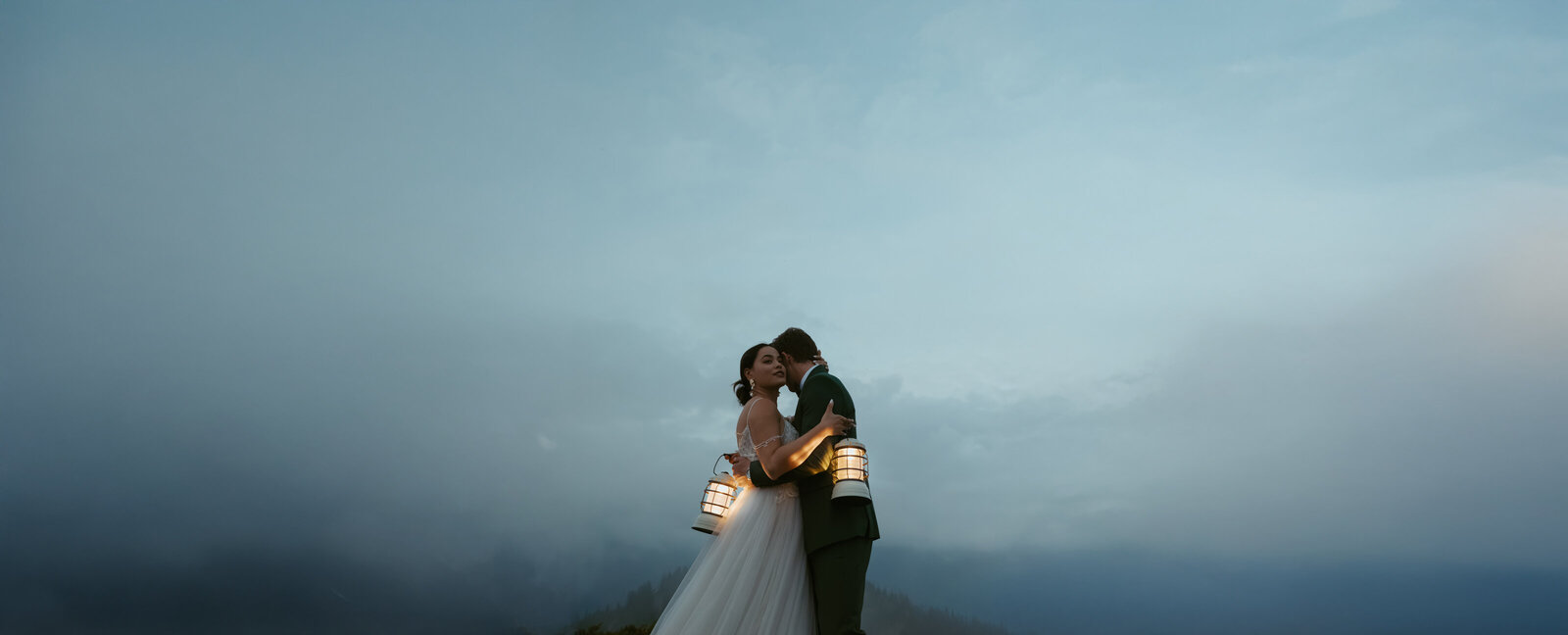 Wedding Couple stand on mountaintop during blue hour