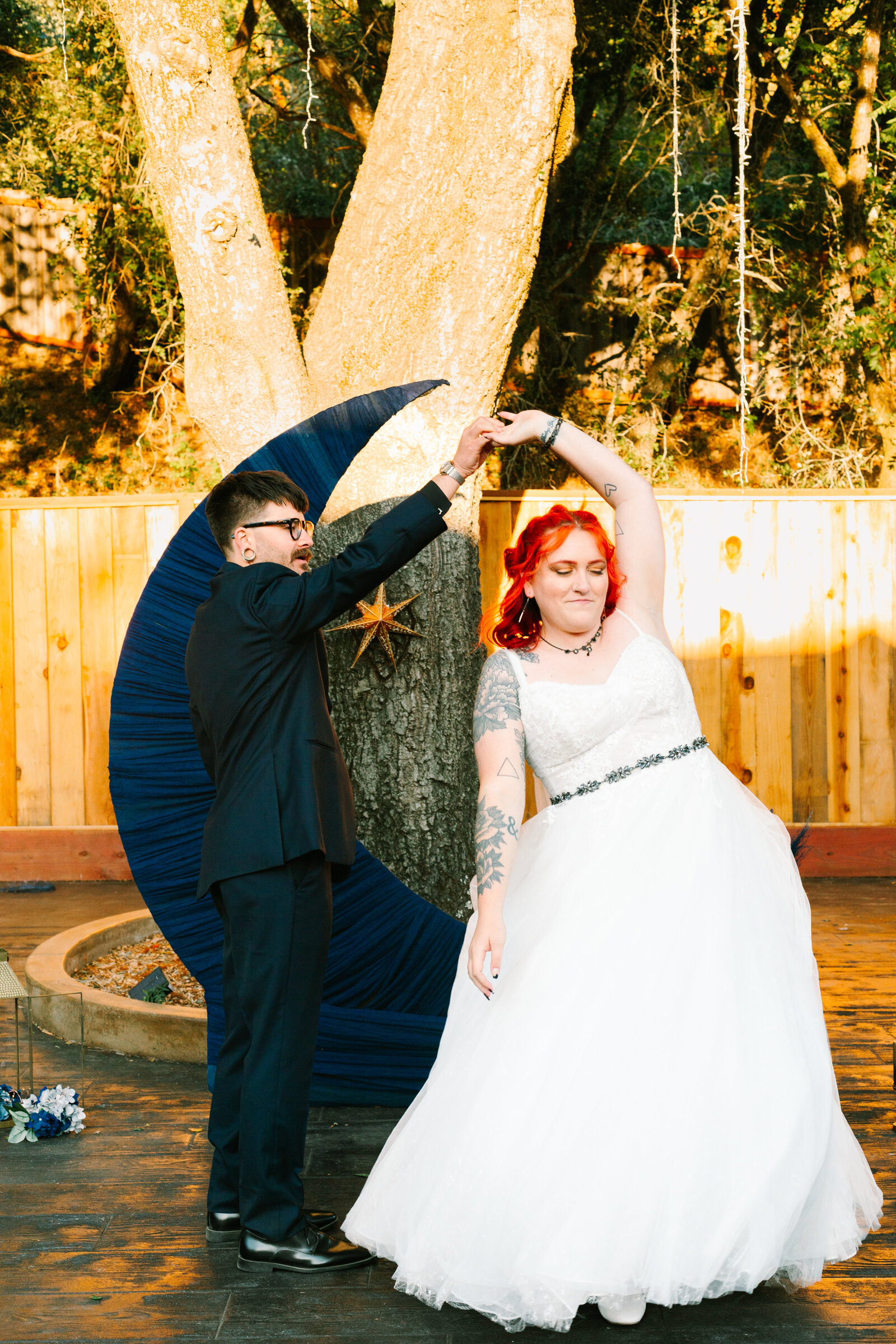 A night under the stars themed wedding, with a moon cutout. A newlywed bride and groom.