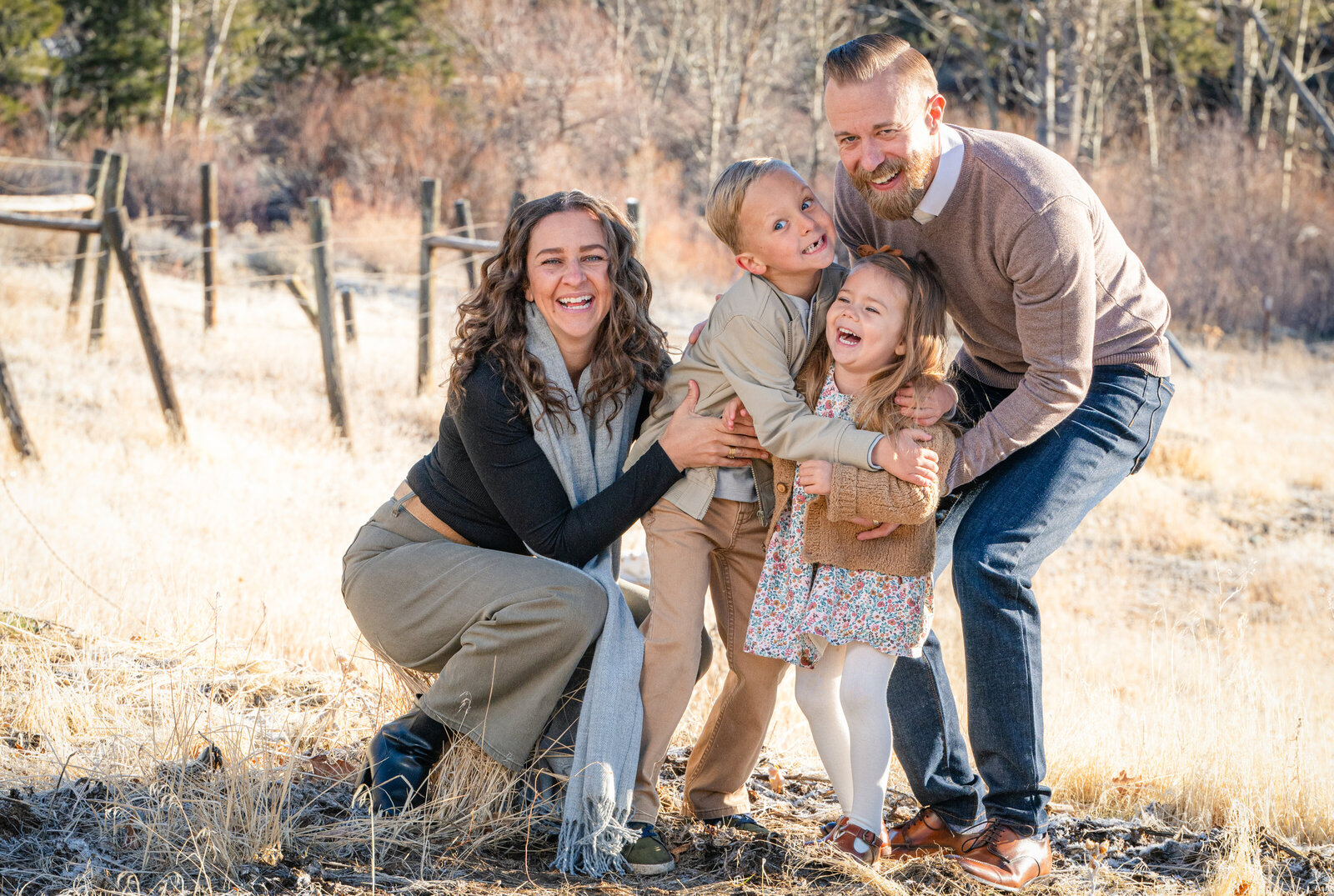 family in a group hug laughing in a verdi field