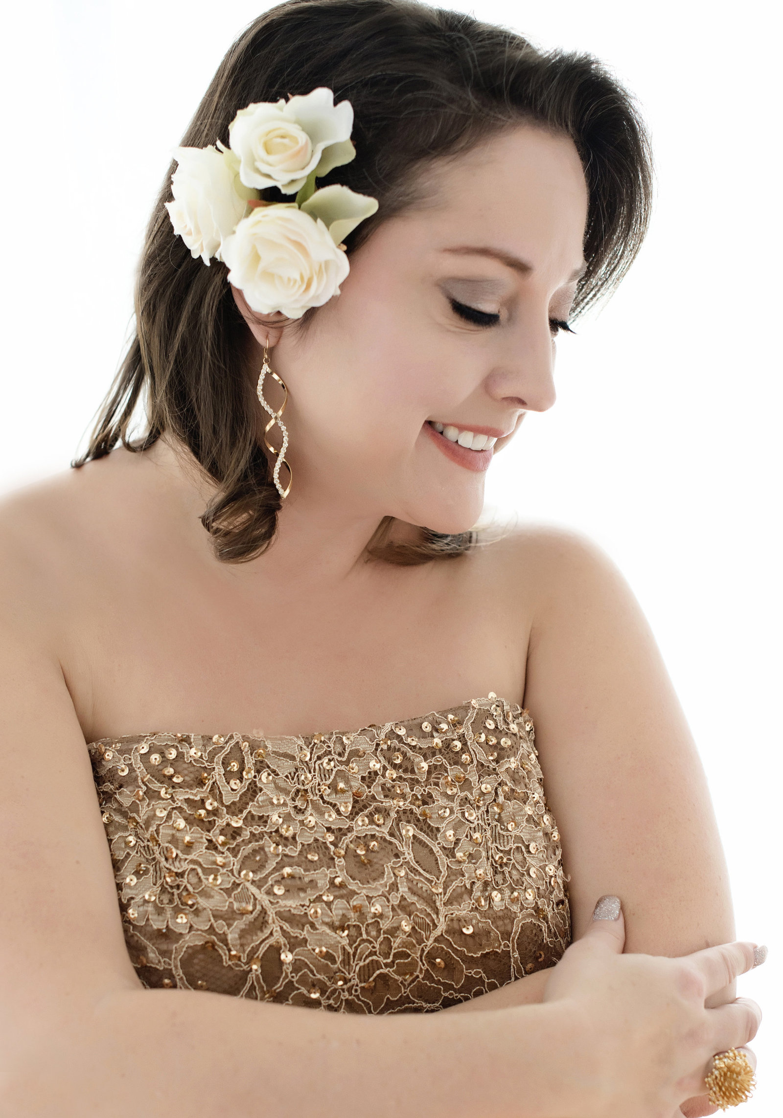 oakville  branding Portrait  of a woman in seqin dess smiling and  happy  headshot and  flowers in her hair looking over her shoulder hugging herself