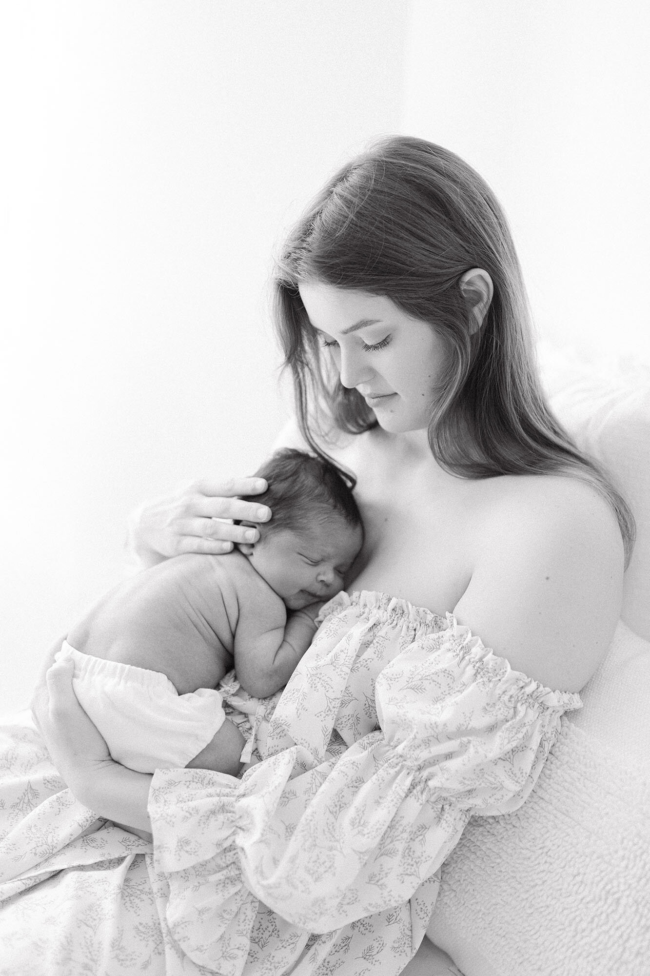 Baby boy sleeping on mom's chest during newborn photo session