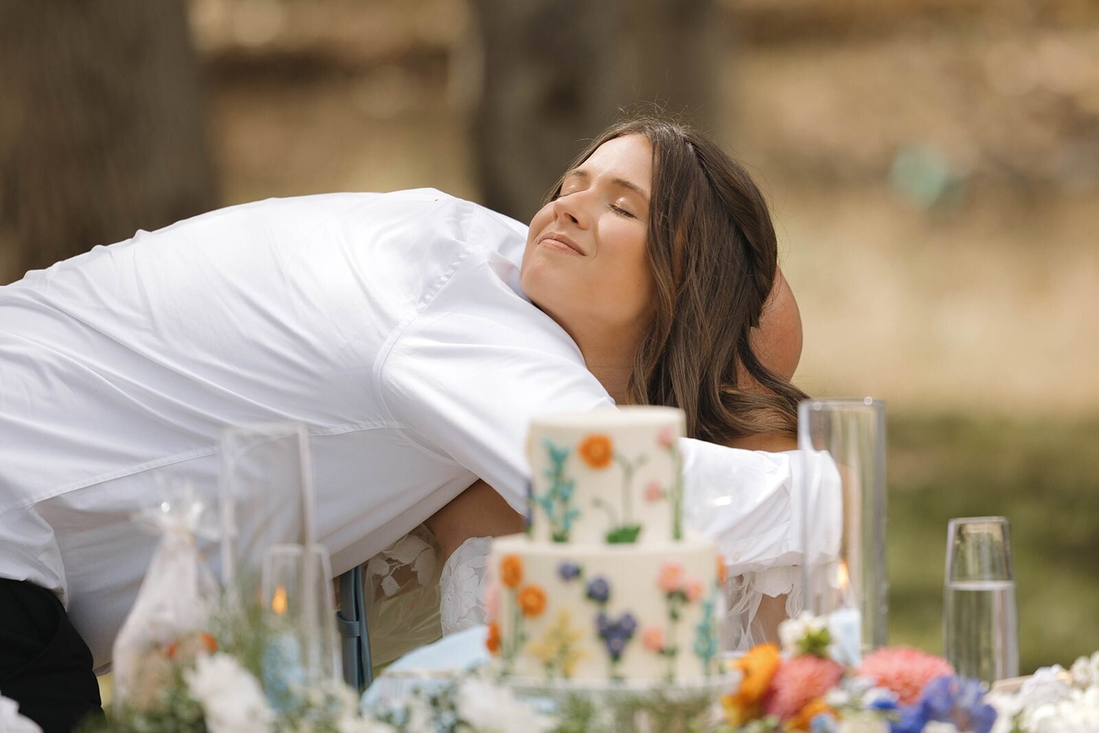 Bride laughing and leaning across the sweetheart table during speeches