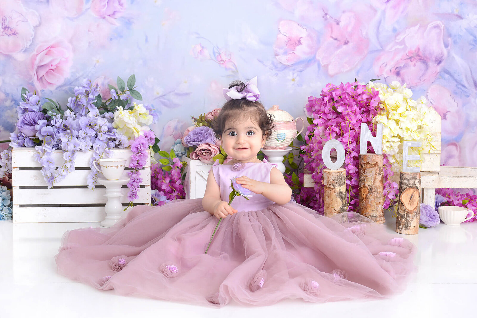 girl wears an elegant purple dollcake dress in front of a classy elegant first birthday shoot background