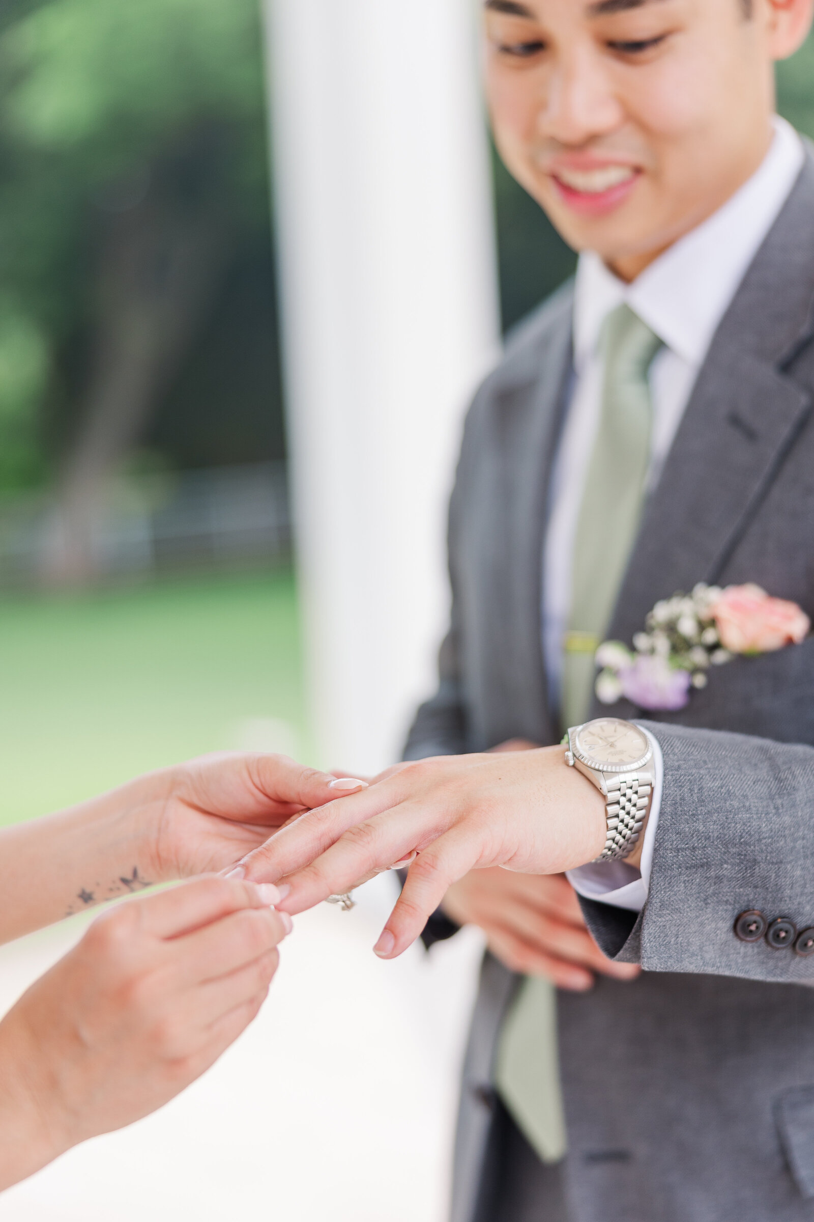 Bride putting ring on groom's finger during wedding ceremony