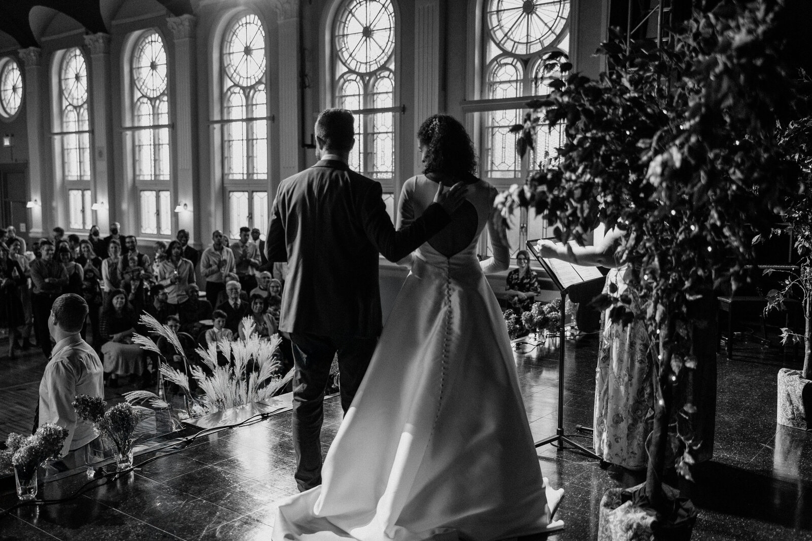Back view shot of the bride and groom facing their families and friends for their closing remarks