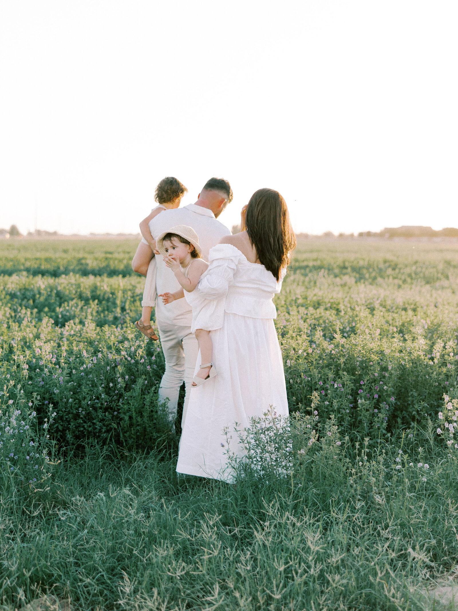Woman and man holding children in a field