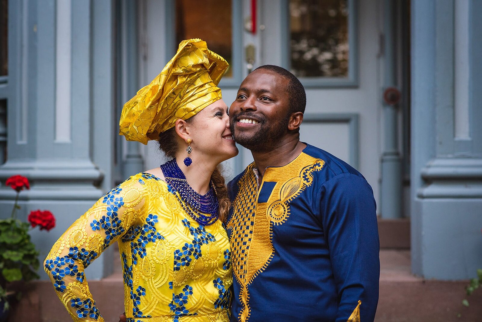 bi-racial couple smiling in African wedding clothes