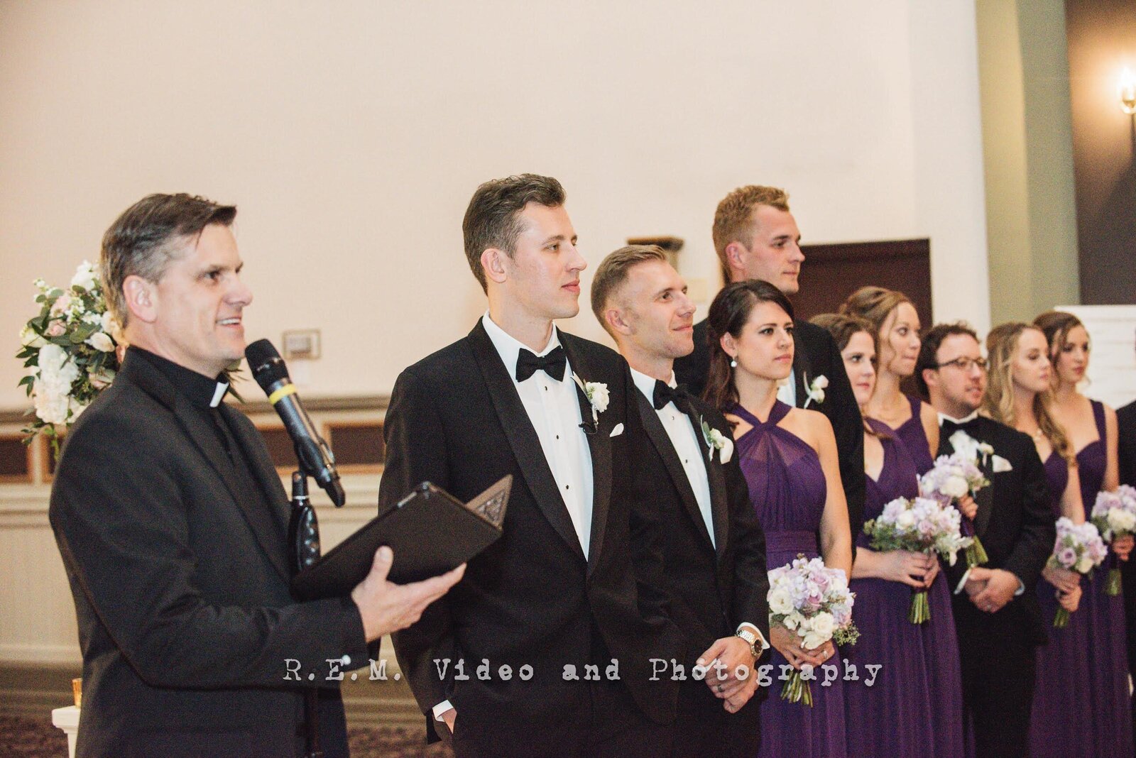 Wedding officiant and groom look down the aisle as bride walks in